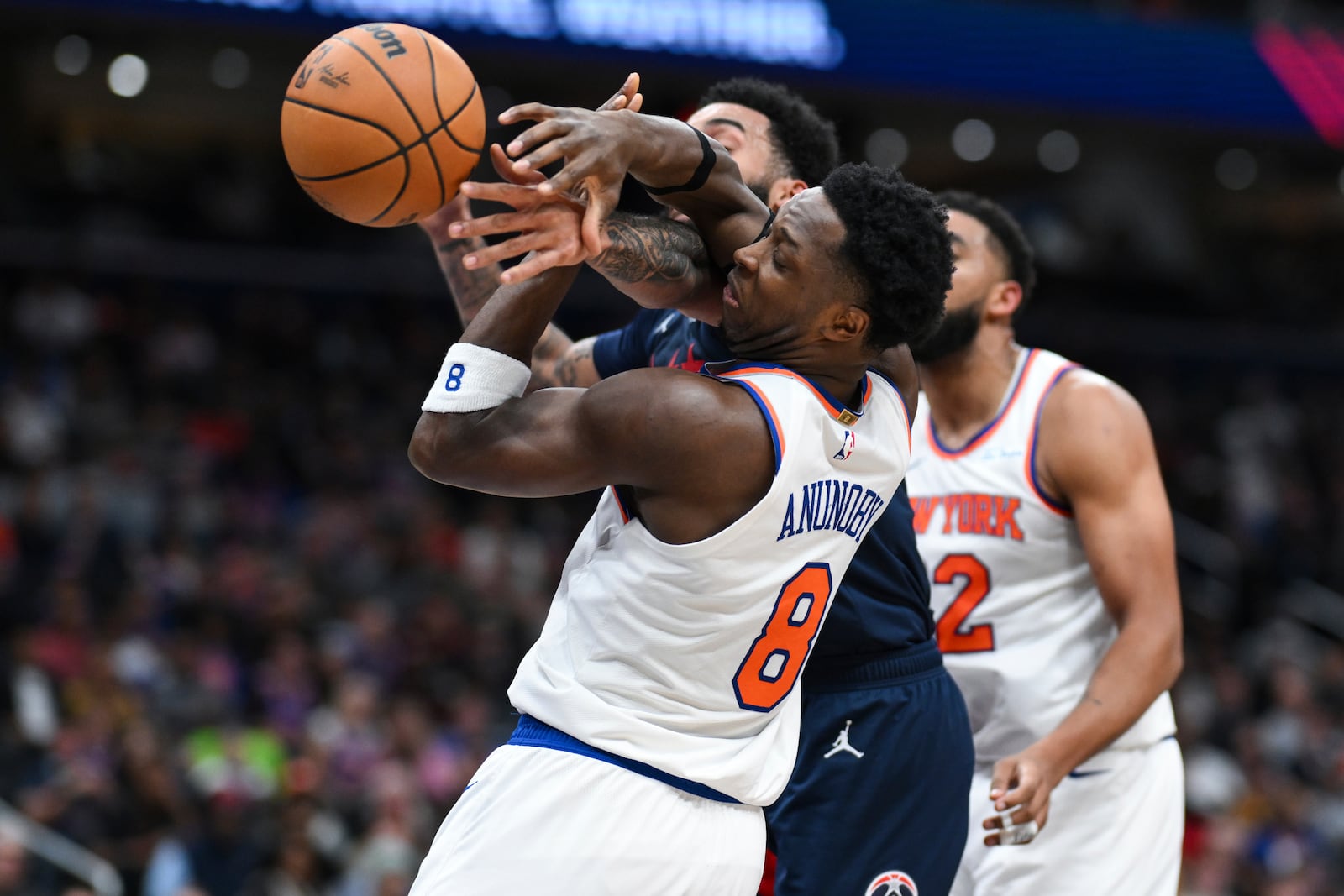 New York Knicks forward OG Anunoby (8) competes for the ball against Washington Wizards forward Justin Champagnie, back left, during the first half of an NBA basketball game, Saturday, Dec. 28, 2024, in Washington. (AP Photo/Terrance Williams)