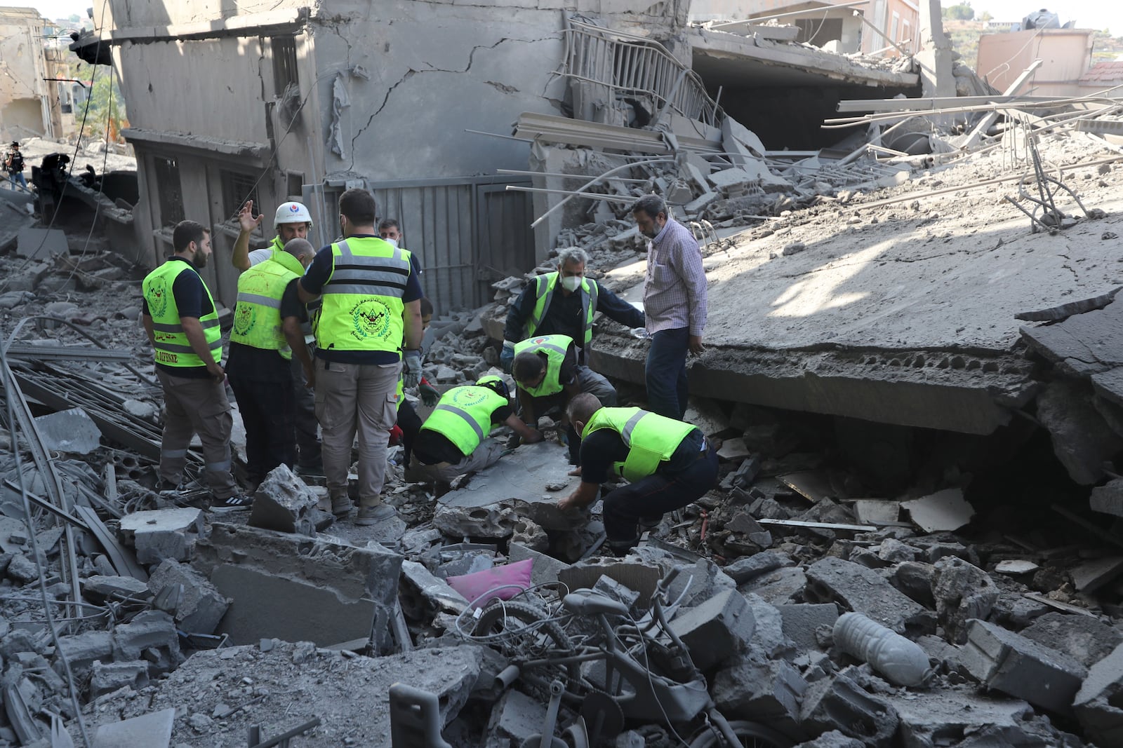 Rescue workers remove rubble, as they search for victims at the site that was hit by Israeli airstrikes in Qana village, south Lebanon, Wednesday, Oct. 16, 2024. (AP Photo/Mohammed Zaatari)