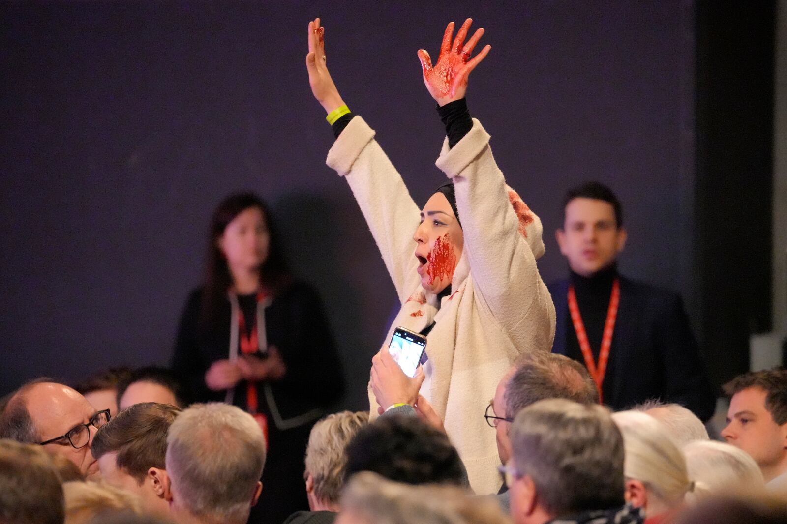 A person disturbes the election campaign start of the German Social Democratic Party (SPD) in Bielefeld, Germany, Monday, Jan. 13, 2025 during a speech of German chancellor Olaf Scholz. (AP Photo/Martin Meissner)