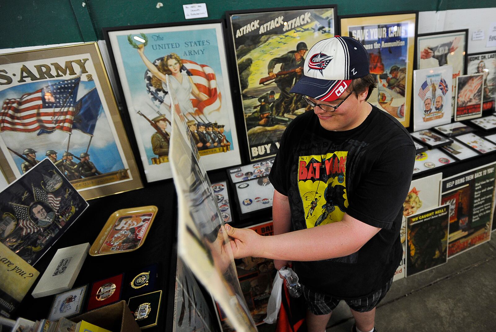 A customer is surrounded by vintage patriotic posters and memorabilia as he looks over a potential purchase during the 2012 Springfield Extravaganza Antique Show and Flea Market at the Clark County Fairgrounds. Staff photo by Bill Lackey