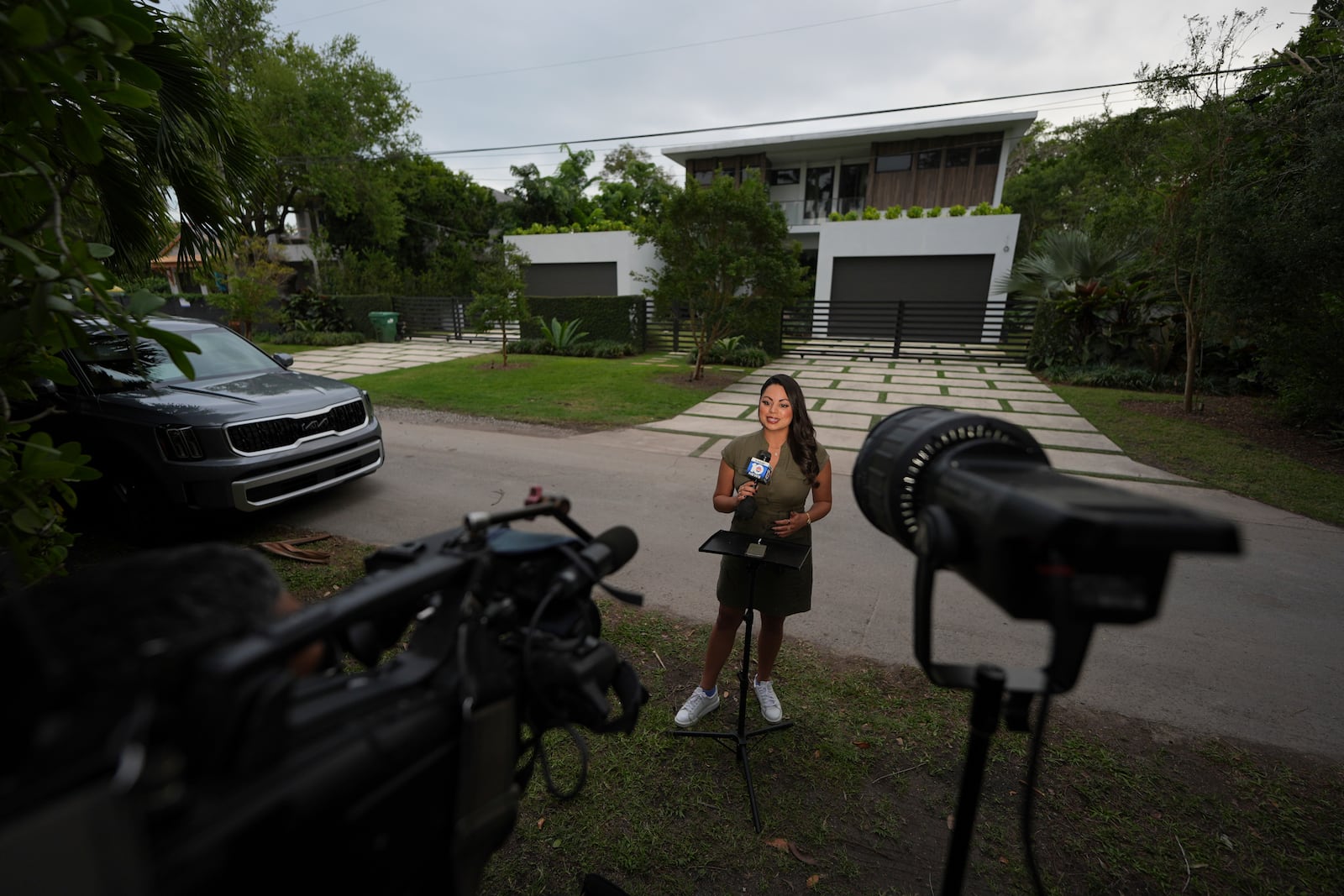 Reporter Bridgette Matter of ABC affiliate WPLG Local 10 speaks to viewers from outside the home where thieves overnight stole a Mercedes and Lamborghini from University of Miami football quarterback Carson Beck, as well as an SUV from his girlfriend, Miami basketball player Hanna Cavinder, Thursday, Feb. 20, 2025, in Miami. (AP Photo/Rebecca Blackwell)