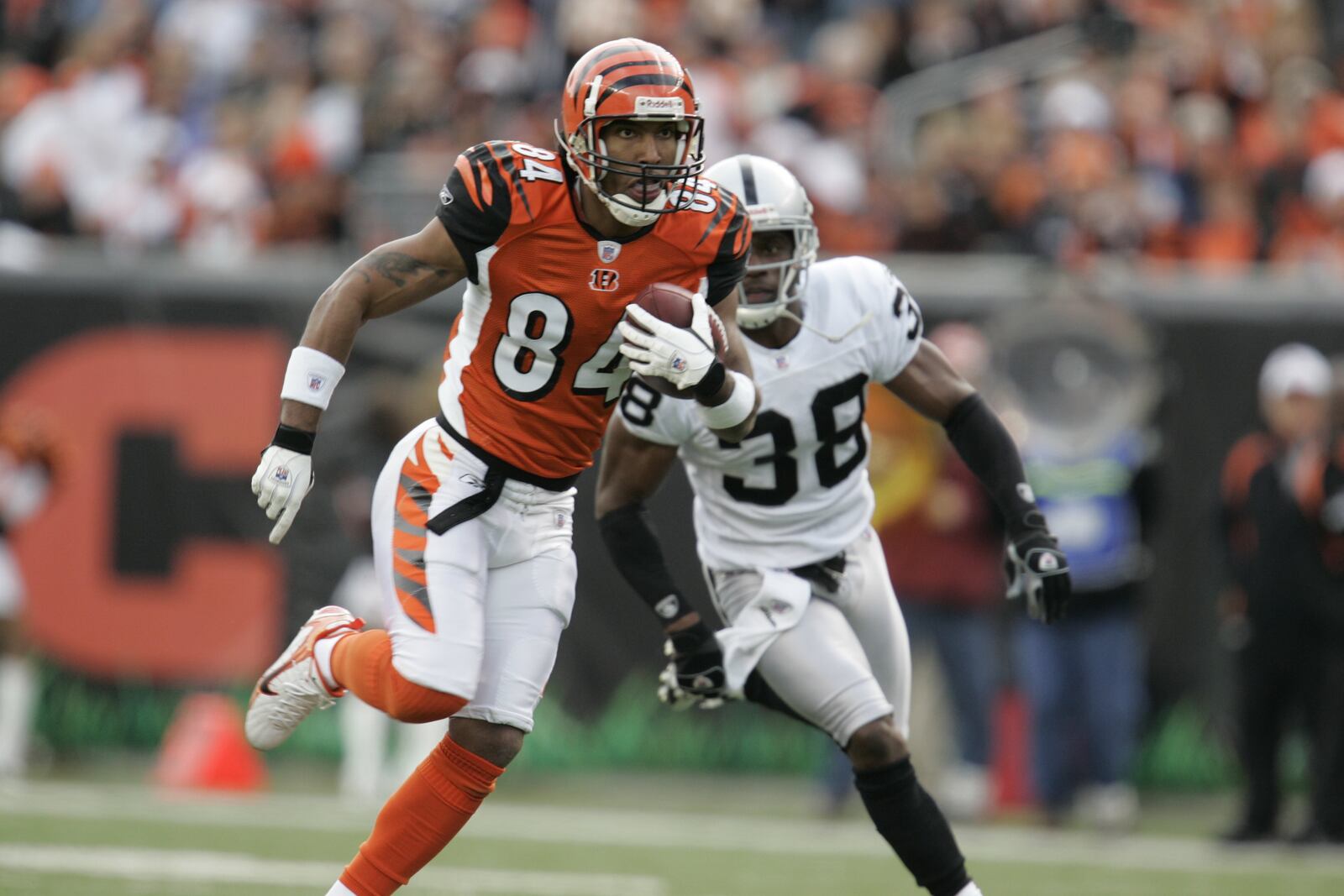 CINCINNATI - DECEMBER 10:  Wide receiver T.J. Houshmandzadeh #84 of the Cincinnati Bengals runs with the ball against defensive back Tyrone Poole #38 of the Oakland Raiders on December 10, 2006 at Paul Brown Stadium in Cincinnati, Ohio. The Bengals defeated the Raiders 27-10. (Photo by David Maxwell/Getty Images)