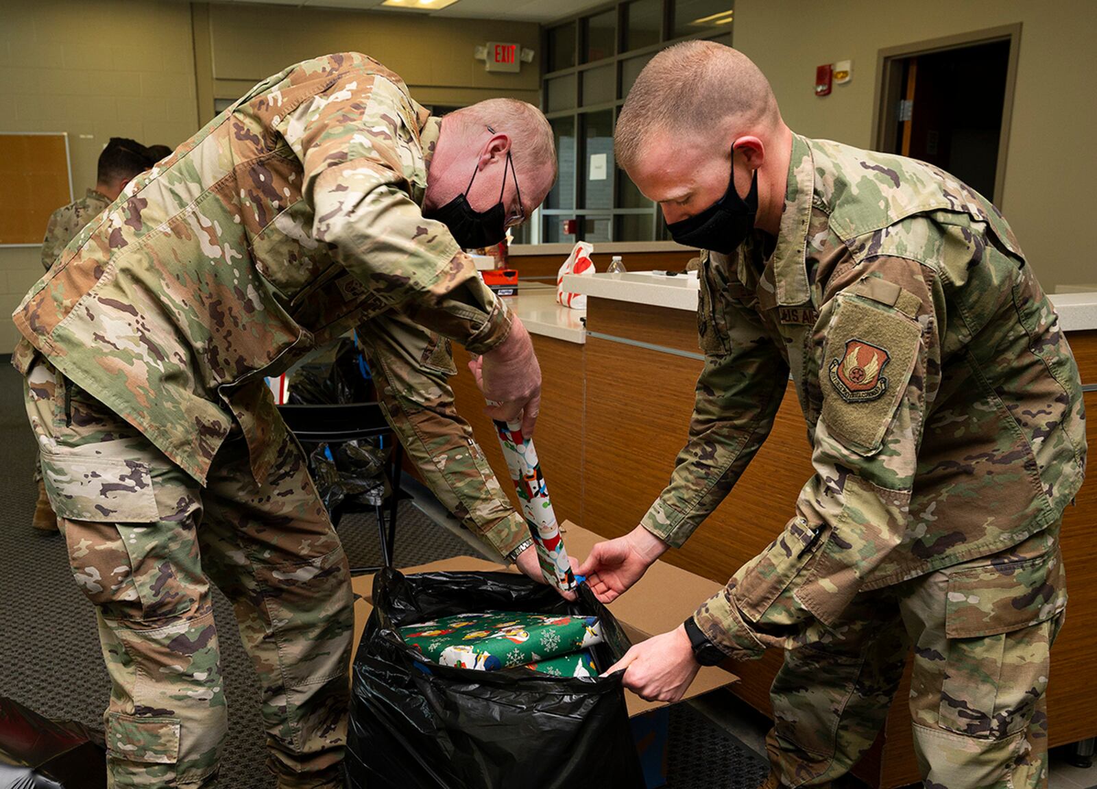 Senior Master Sgt. Timothy Sigafoos (left), National Air and Space Intelligence Center first sergeant, and Tech. Sgt. Austin Edington, U.S. Air Force School of Aerospace Medicine, fill a bag with donated presents for a Wright-Patterson Air Force Base family Dec. 3. The base’s First Sergeants Council sponsored the annual Adopt-A-Family Program to ensure families in need have something for children on Christmas. U.S. AIR FORCE PHOTO/R.J. ORIEZ