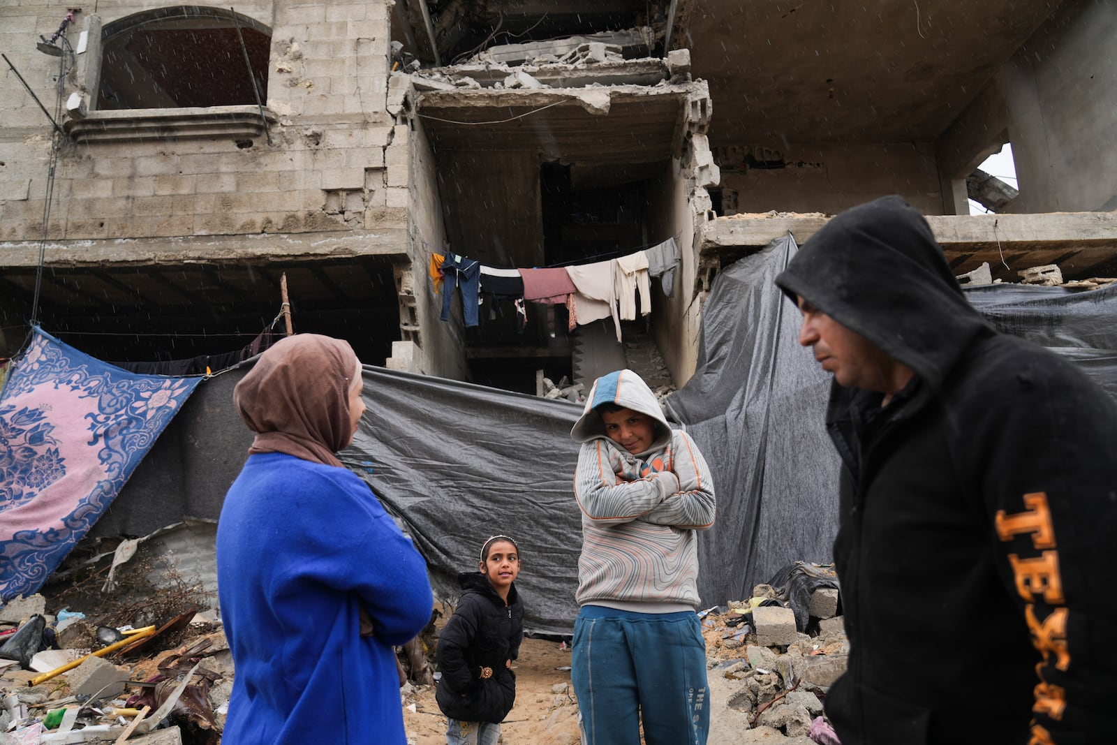 Members of the Tamboura family stand outside their four-story home, which was struck by an Israeli airstrike on Oct. 20, 2023, in Beit Lahiya, northern Gaza Strip, Friday, Feb. 21, 2025. (AP Photo/Abdel Kareem Hana)