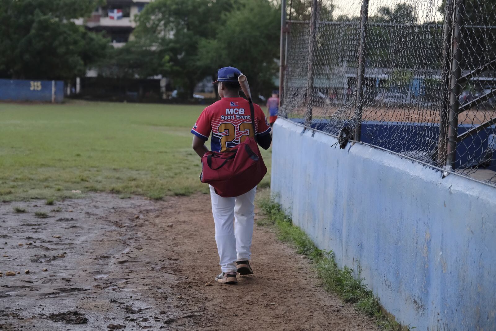 A teenage baseball player, wearing an MCB Sport Event jersey, arrives for practice at the Trinitarios ballpark in Santo Domingo, Dominican Republic, Wednesday, Feb. 5, 2025. (AP Photo/Ricardo Hernandez)