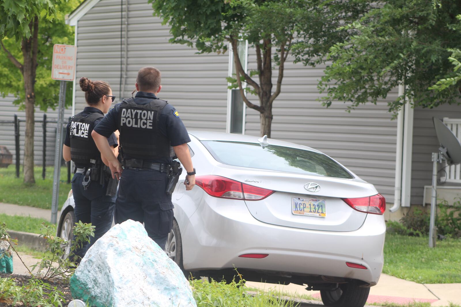 Two Dayton police officers examine a Hyundai that was parked in the middle of the street at the intersection of Steele Avenue and Clover Street at 2:15 p.m. Friday, Aug. 11, 2023. Police said it was a stolen vehicle that they recovered.  Thieves have been targeting Hyundai and Kia vehicles because they have a security flaw that makes them easy to steal. CORNELIUS FROLIK / STAFF