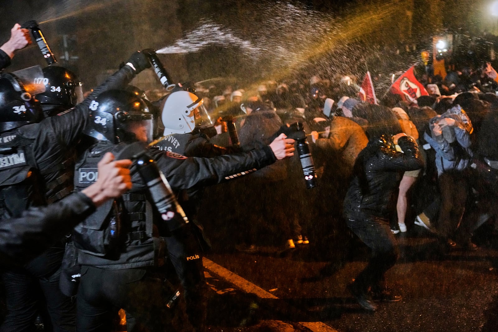 Police officers use pepper spray during clashes with people as they protest against the arrest of Istanbul's Mayor Ekrem Imamoglu, in Istanbul, Turkey, Friday, March 21, 2025. (AP Photo/Khalil Hamra)