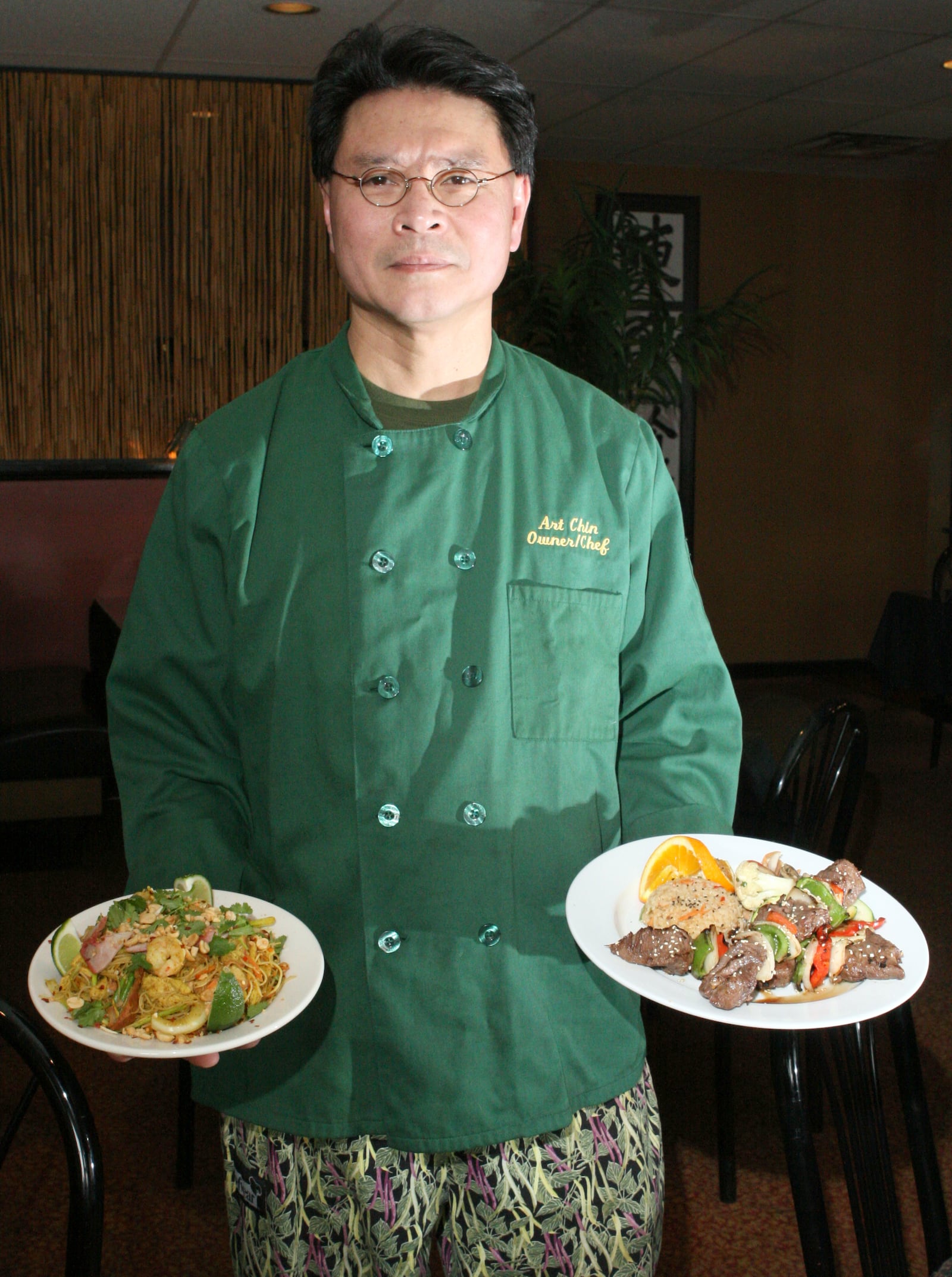 Art Chin, Owner and Chef of Chin's Ginger Grill in Tipp City, presents his entrees of Classic Singapore Noodles (left) and marinated and grilled tenderloin Kabob (right). March 31, 2008.