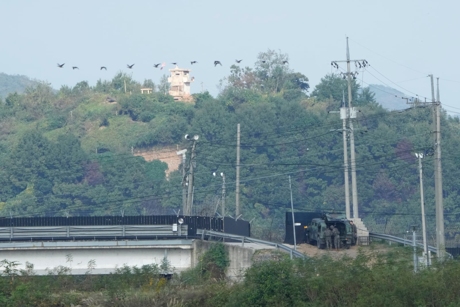 A North Korean military guard post, top, and South Korean army soldiers, bottom, are seen from Paju, South Korea, near the border with North Korea, Thursday, Oct. 10, 2024. (AP Photo/Ahn Young-joon)