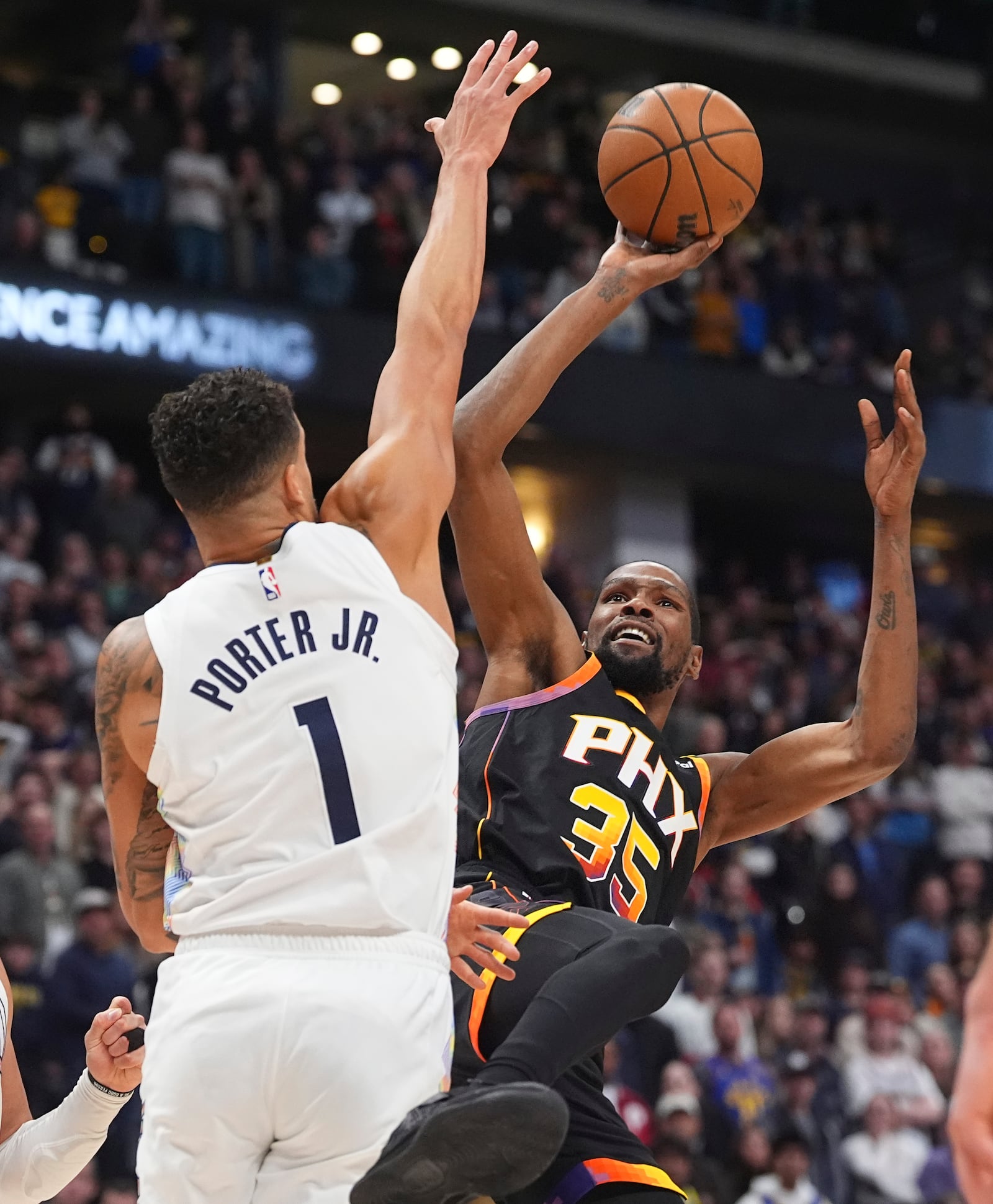 Denver Nuggets forward Michael Porter Jr., left, fouls Phoenix Suns forward Kevin Durant in overtime of an NBA basketball game Friday, March 7, 2025, in Denver. (AP Photo/David Zalubowski)