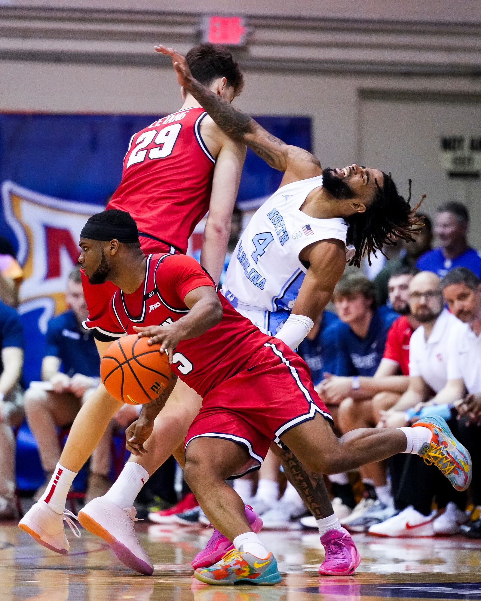 Dayton guard Posh Alexander, left, fouls North Carolina guard RJ Davis (4) as Dayton forward Amael L'Etang (29) guards during the second half of an NCAA college basketball game at the Maui Invitational Monday, Nov. 25, 2024, in Lahaina, Hawaii. (AP Photo/Lindsey Wasson)