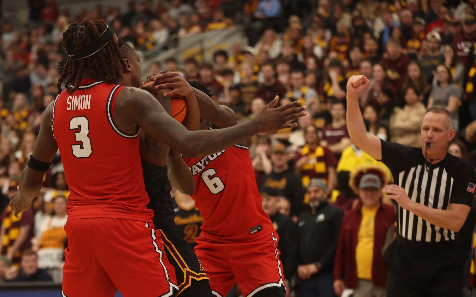 Dayton's Enoch Cheeks and Jaiun Simon go for a steal in the final seconds against Loyola Chicago on Friday, Feb. 21, 2025, at Gentile Arena in Chicago. David Jablonski/Staff