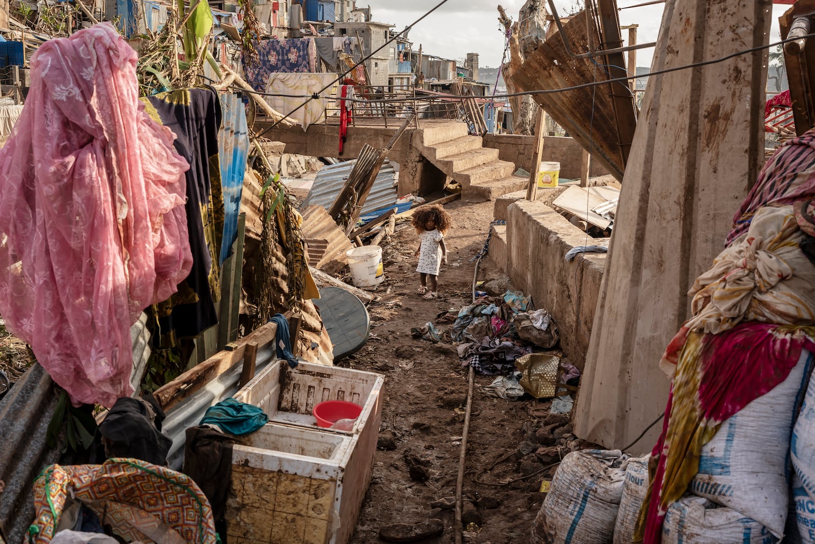 A young girl walks in the Kaweni slum on the outskirts of Mamoudzou, in the French Indian Ocean island of Mayotte, Thursday, Dec. 19, 2024, after Cyclone Chido. (AP Photo/Adrienne Surprenant)