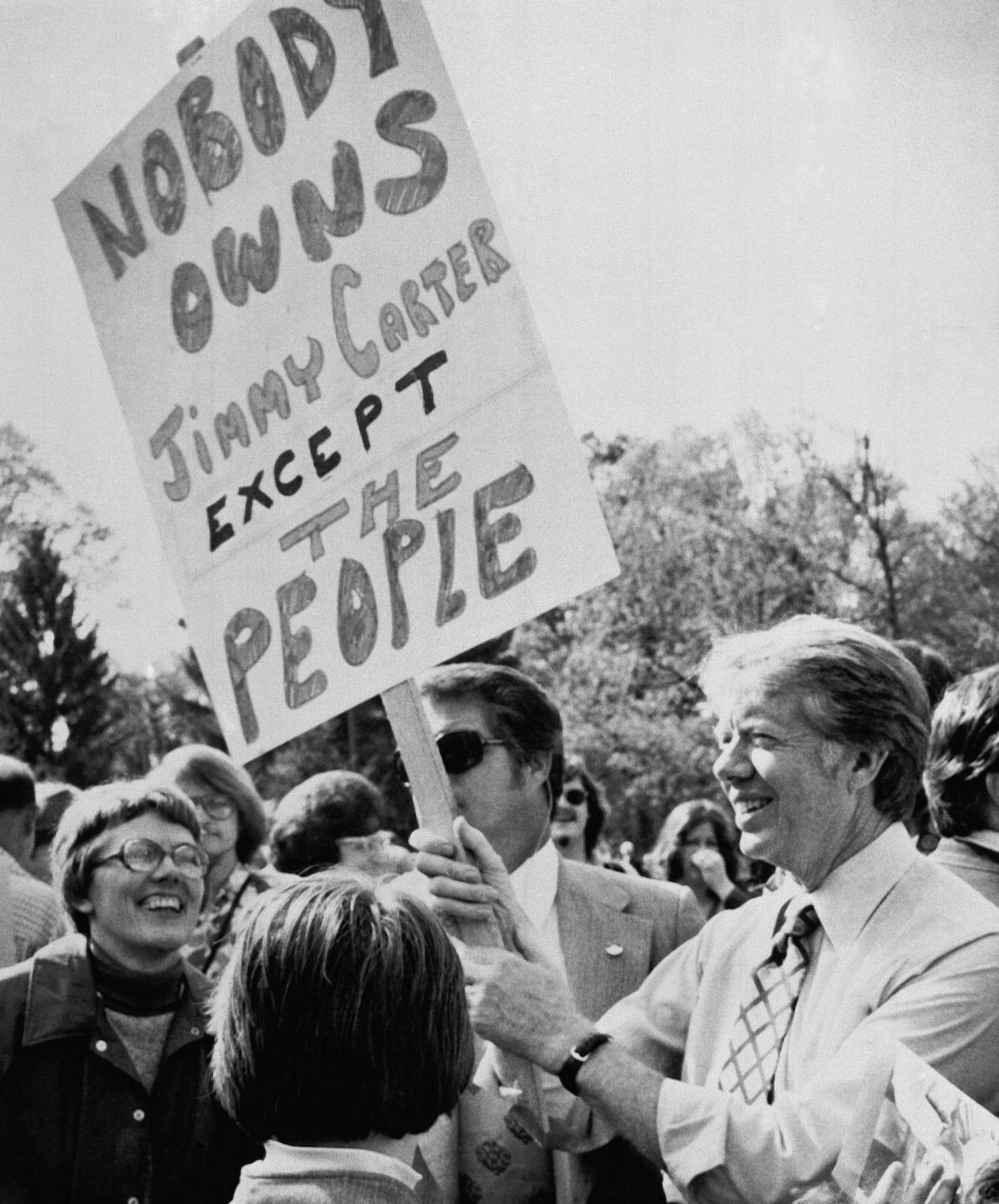 FILE - Democratic presidential hopeful, former Georgia Gov. Jimmy Carter, right, holds a poster as he mingles with the crowd during a campaign visit in Williamsport, Pa., April 24, 1976. (AP Photo, File)