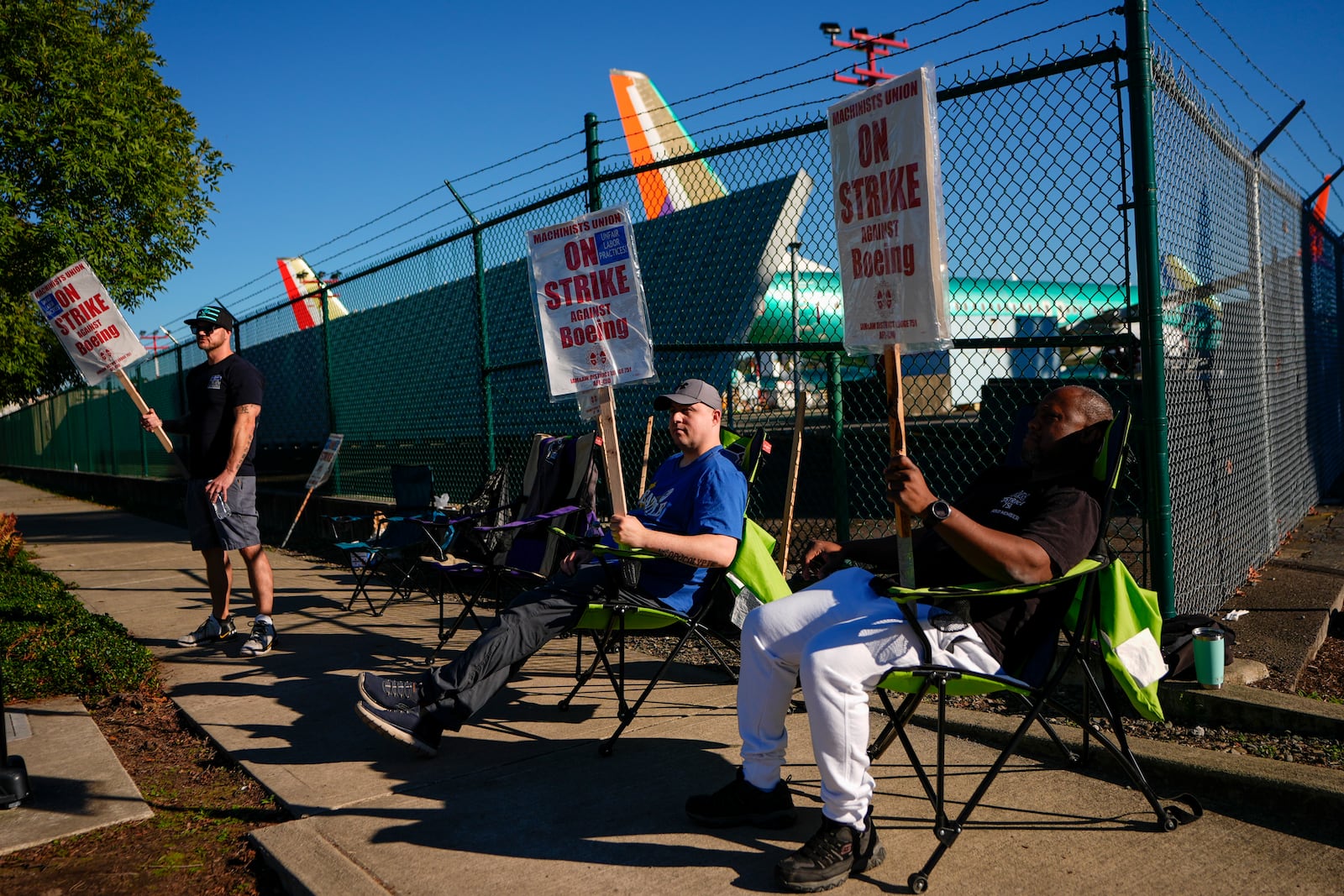 FILE - Boeing 737 Max aircrafts are seen behind fences as striking Boeing workers picket on Sept. 24, 2024, next to the company's facilities in Renton, Wash. (AP Photo/Lindsey Wasson, File)