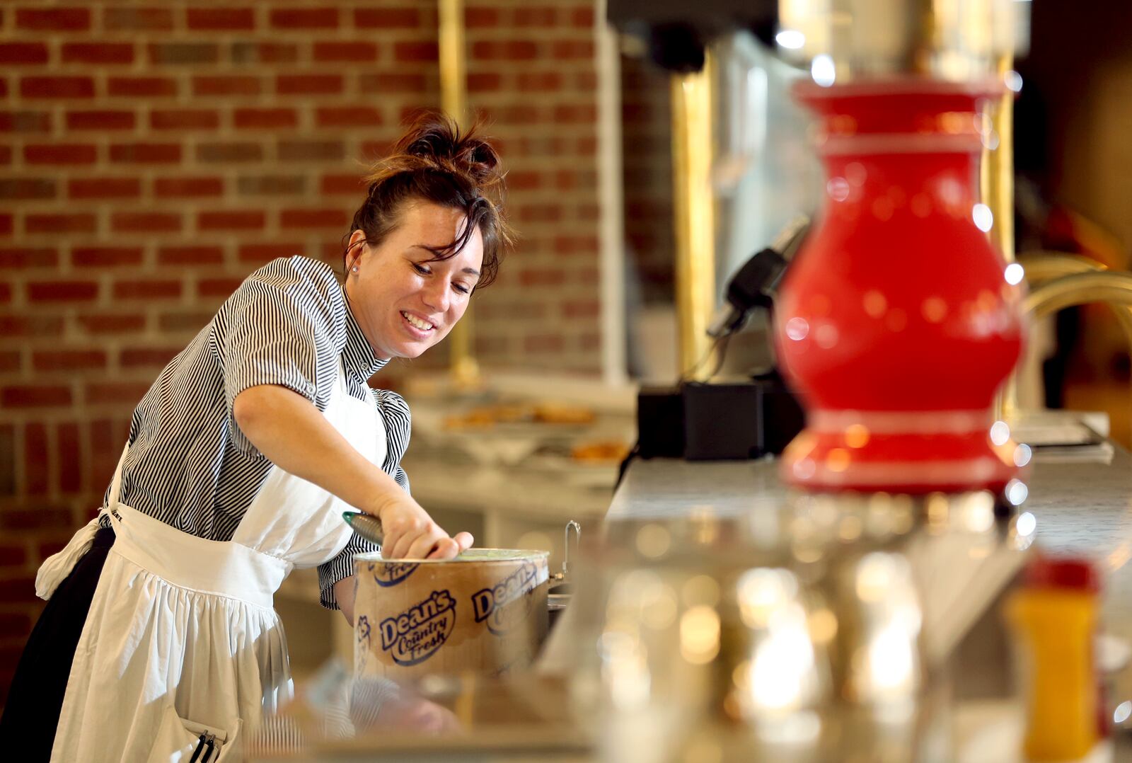 Alicia Johnson, a server at Carillon Historical Park's new reimagined Culp's Cafe, makes a shake at the soda fountain. LISA POWELL / STAFF