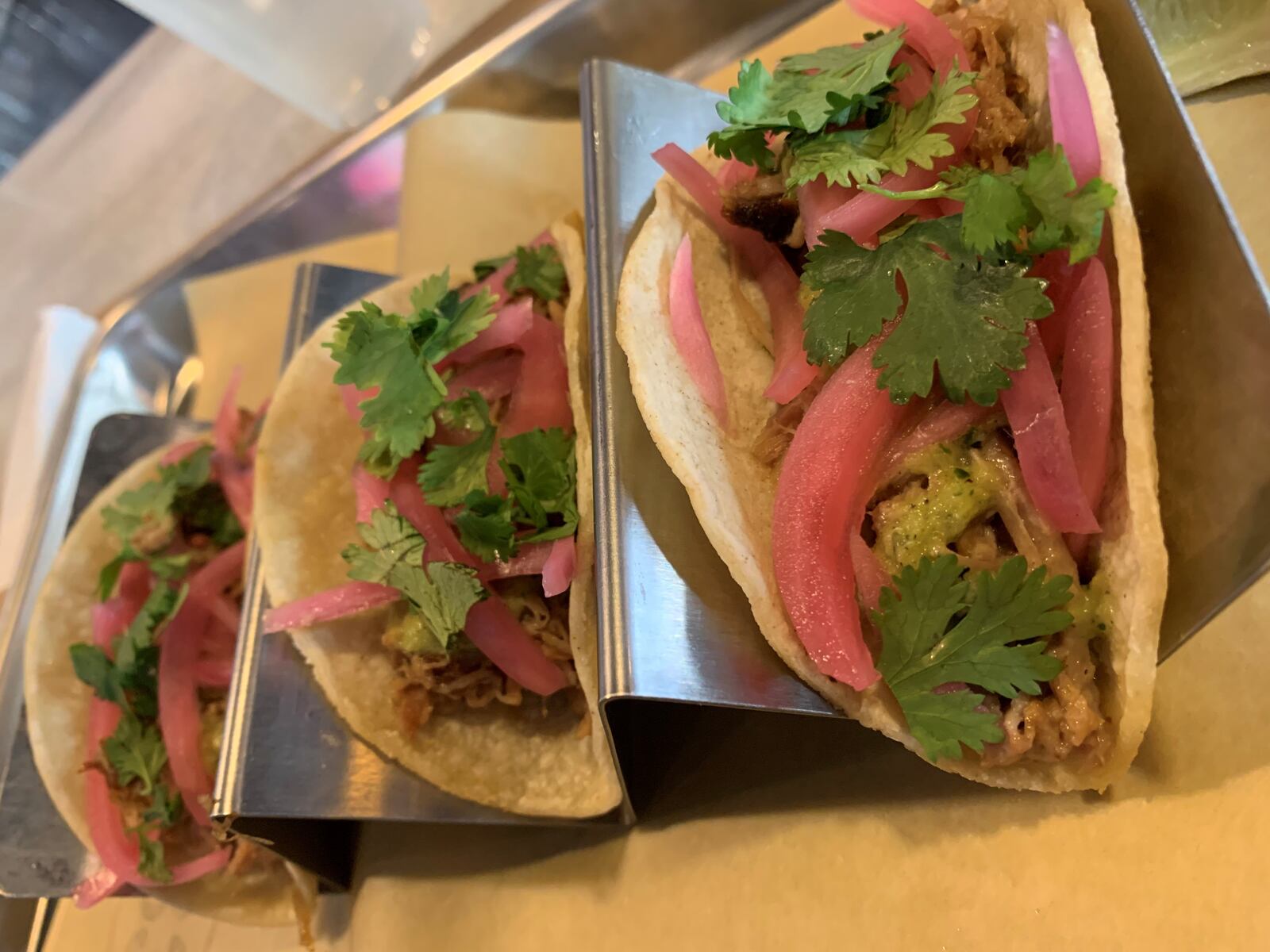 Table 33 in Dayton's pork carnitas tacos topped with bright pickled onion, fresh cilantro and salsa verde. ALEXIS LARSEN/CONTRIBUTED