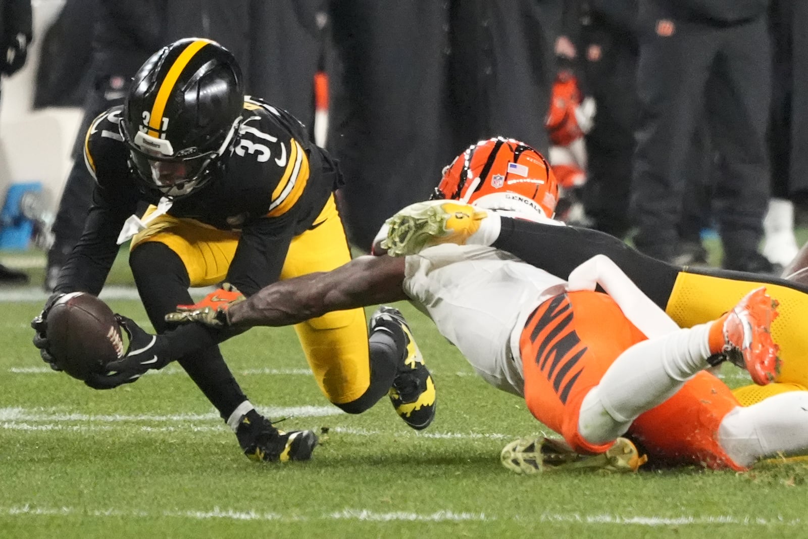 Pittsburgh Steelers cornerback Beanie Bishop Jr., left, intercepts a pass intended for Cincinnati Bengals wide receiver Ja'Marr Chase, center, that was broken up by Steelers linebacker Patrick Queen, right, during the first half of an NFL football game in Pittsburgh Saturday, Jan. 4, 2025. (AP Photo/Gene J. Puskar)