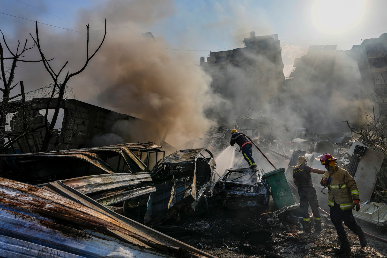 Civil defense workers extinguish a fire as smoke rises from the site of an Israeli airstrike in Dahiyeh, Beirut, Lebanon, Friday, Nov. 1, 2024. (AP Photo/Hassan Ammar)