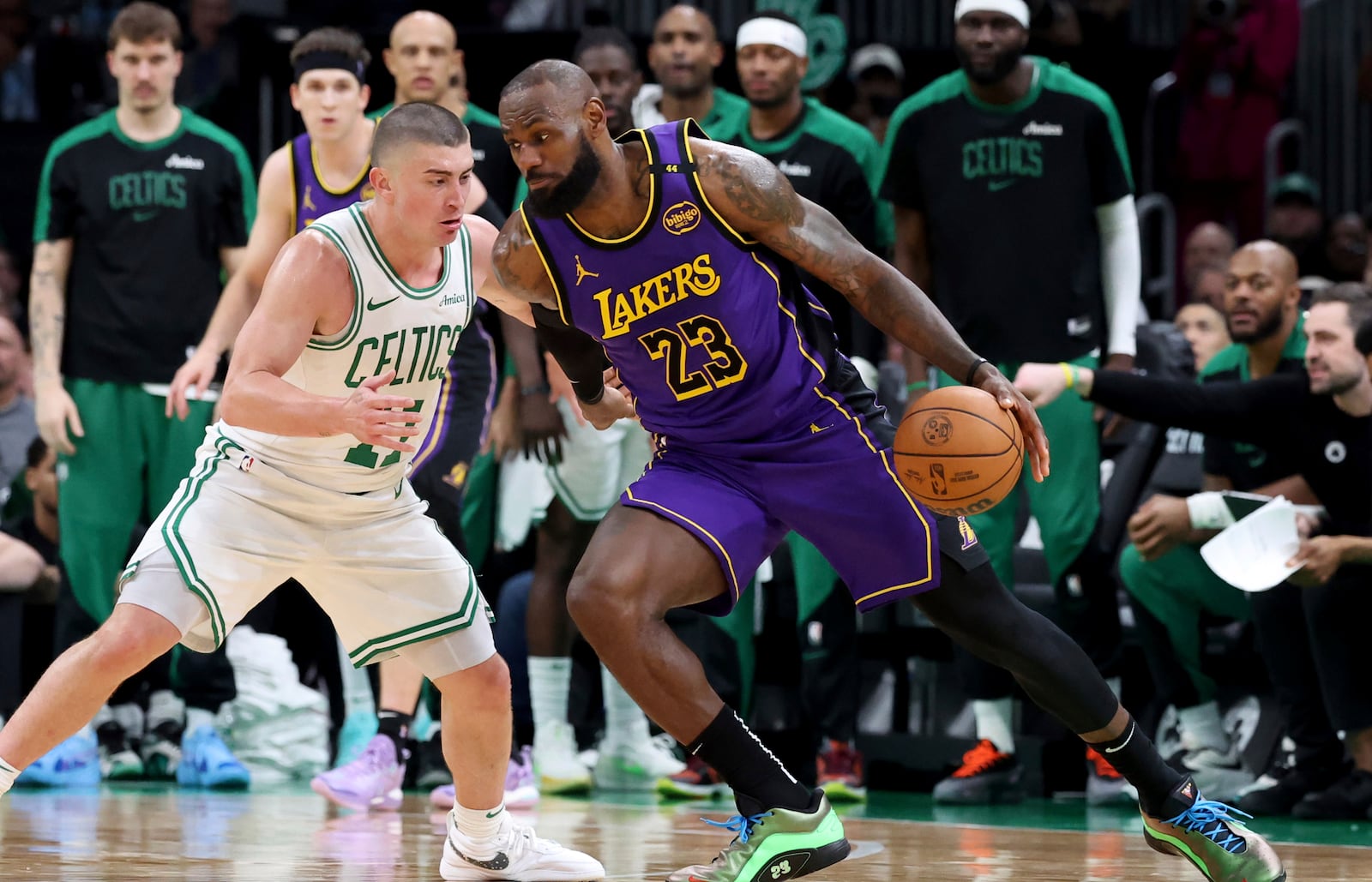 Los Angeles Lakers forward LeBron James (23) defends the ball from Boston Celtics guard Payton Pritchard, left, during the second half of an NBA basketball game, Saturday, March 8, 2025, in Boston. (AP Photo/Mark Stockwell)