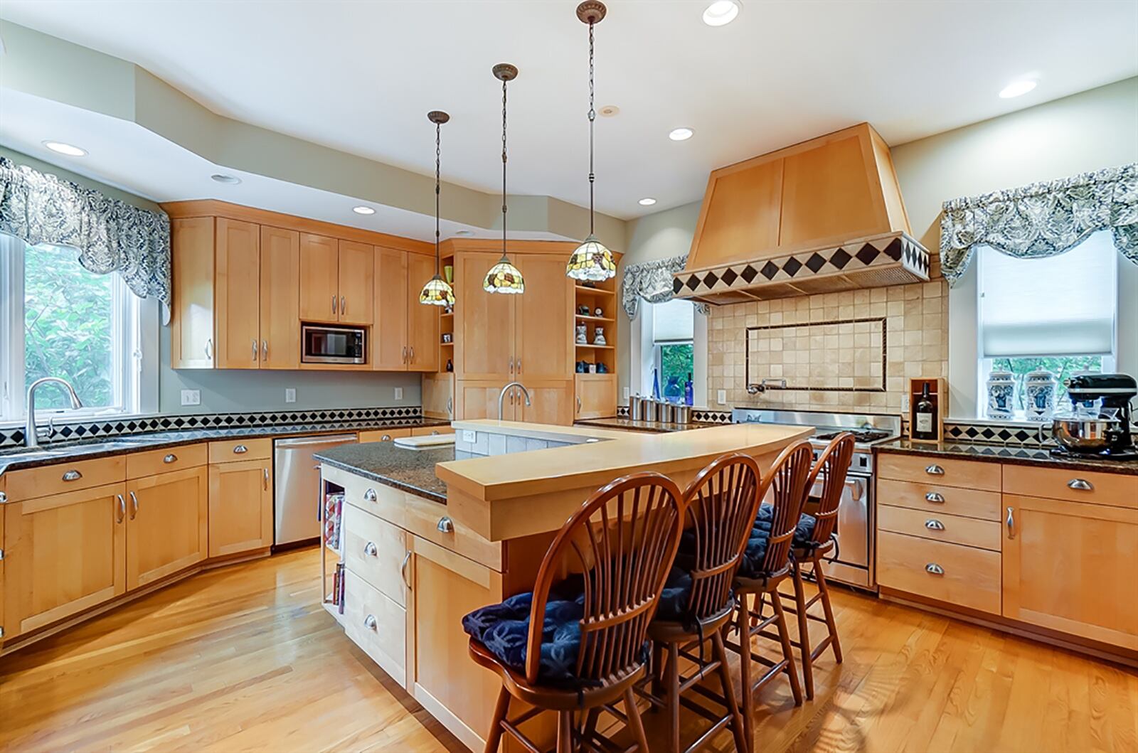 Updated cabinetry provides the kitchen with storage space for just about every need. A corner pantry has pull-out shelves and appliance garages. A double oven has a grill, griddle and four gas burners. Ceramic-tile accents the wall space below the large hood-vent and has a pot-filler faucet. CONTRIBUTED PHOTO