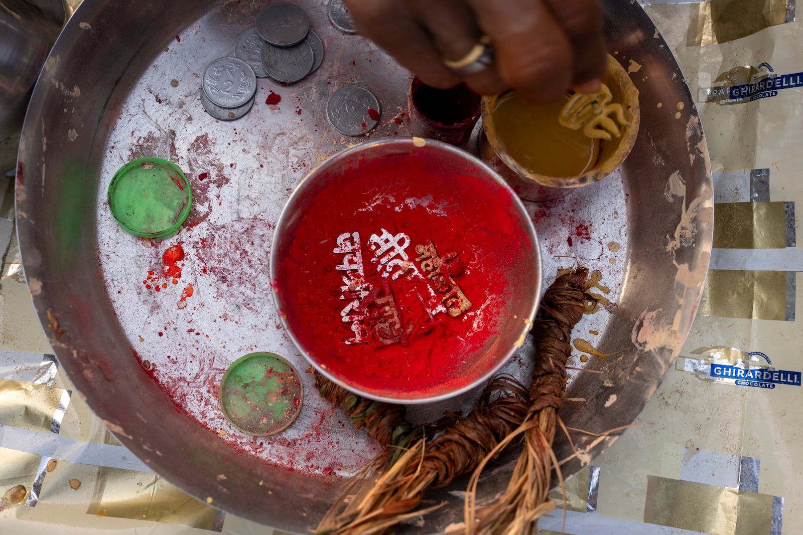 Tools for sacred marks, sandalwood paste, vermillion powder and metal stamps of Hindu gods' names are placed in a tray by a Hindu priest at the confluence of the Ganges, the Yamuna, and the Saraswati rivers during the 45-day-long Maha Kumbh festival in Prayagraj, India, Tuesday, Jan. 14, 2025. (AP Photo/Ashwini Bhatia)