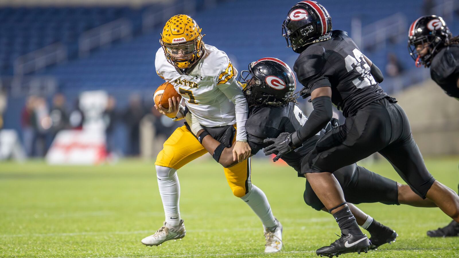 Alter High School junior quarterback Gavin Connor is tackled by several Cleveland Glenville defenders during the Division IV state championship game on Saturday night at Tom Benson Hall of Fame Stadium in Canton. CONTRIBUTED PHOTO BY MICHAEL COOPER