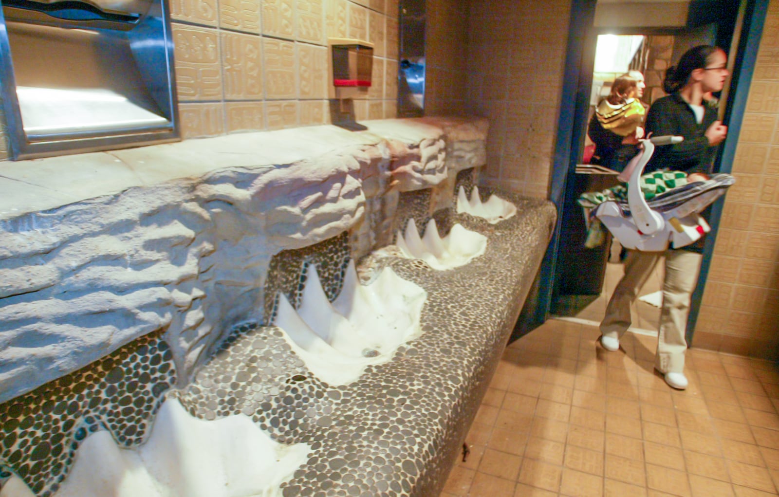 Gretchen Carey of Dayton and her family take a look around the bathrooms of the Kon-Tiki movie theatre Tuesday morning before demolition of the building began. The theatre was know for its South Pacific decor. The theatre opened in 1968 and closed in 1999. Photo by Lisa Powell