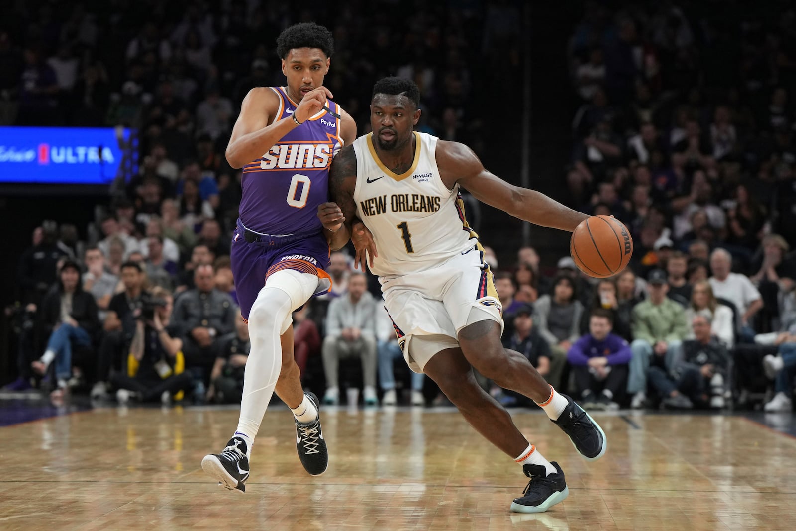 New Orleans Pelicans forward Zion Williamson (1) drives past Phoenix Suns forward Ryan Dunn during the first half of an NBA basketball game, Thursday, Feb. 27, 2025, in Phoenix. (AP Photo/Rick Scuteri)