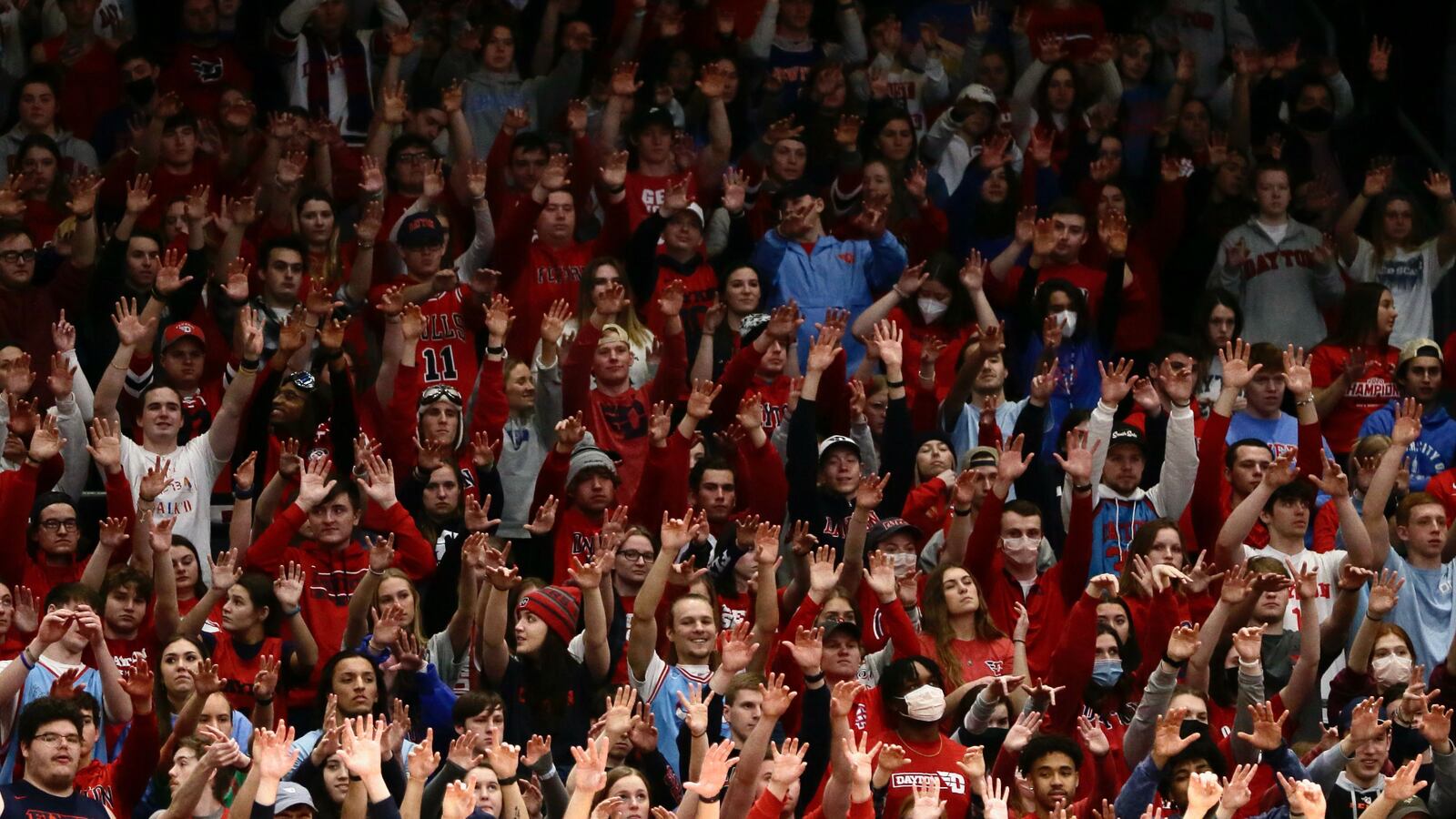 Dayton fans in the Red Scare student section hold up their hands as the Flyers shoot a free throw against George Washington on Saturday, Feb. 12, 2022, at UD Arena. David Jablonski/Staff