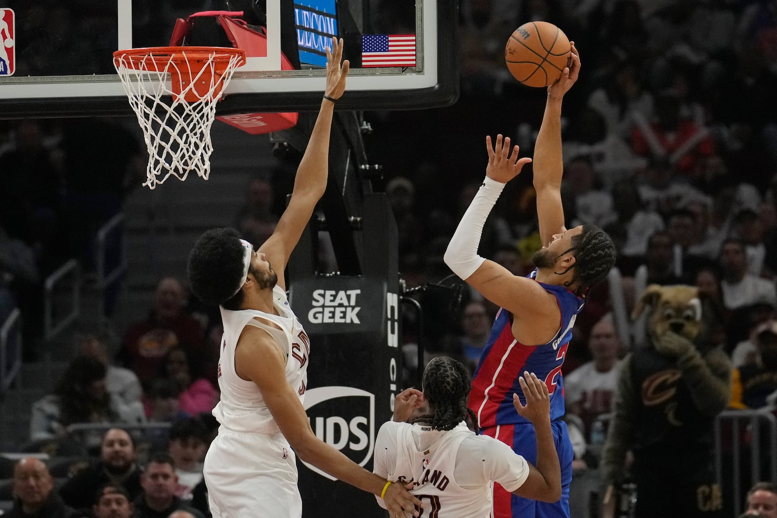 Detroit Pistons guard Cade Cunningham, right, shoots in front of Cleveland Cavaliers guard Darius Garland, center and center Jarrett Allen, left, in the first half of an NBA basketball game, Friday, Oct. 25, 2024, in Cleveland. (AP Photo/Sue Ogrocki)