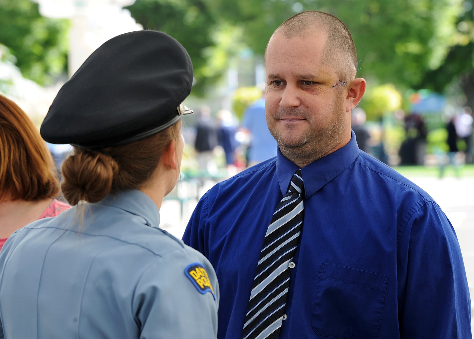 Dayton Police Officer Thadeu Holloway, talks with other officers during the Montgomery County 14th Annual Law Enforcrment Memorial Ceremony Monday Sept. 27, 2021. Holloway, an eight-year veteran of the Dayton Police Department, was shot in the left side of his face during a struggle with a suspect last Thursday.  MARSHALL GORBY\STAFF