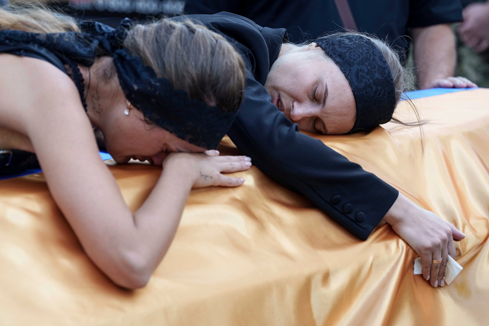 FILE - Relatives cry over the coffin of a Ukrainian serviceman killed in a Russian rocket attack at a Ukrainian military academy, during his funeral ceremony in Poltava, Ukraine, Saturday Sept. 7, 2024. (AP Photo/Evgeniy Maloletka, File)