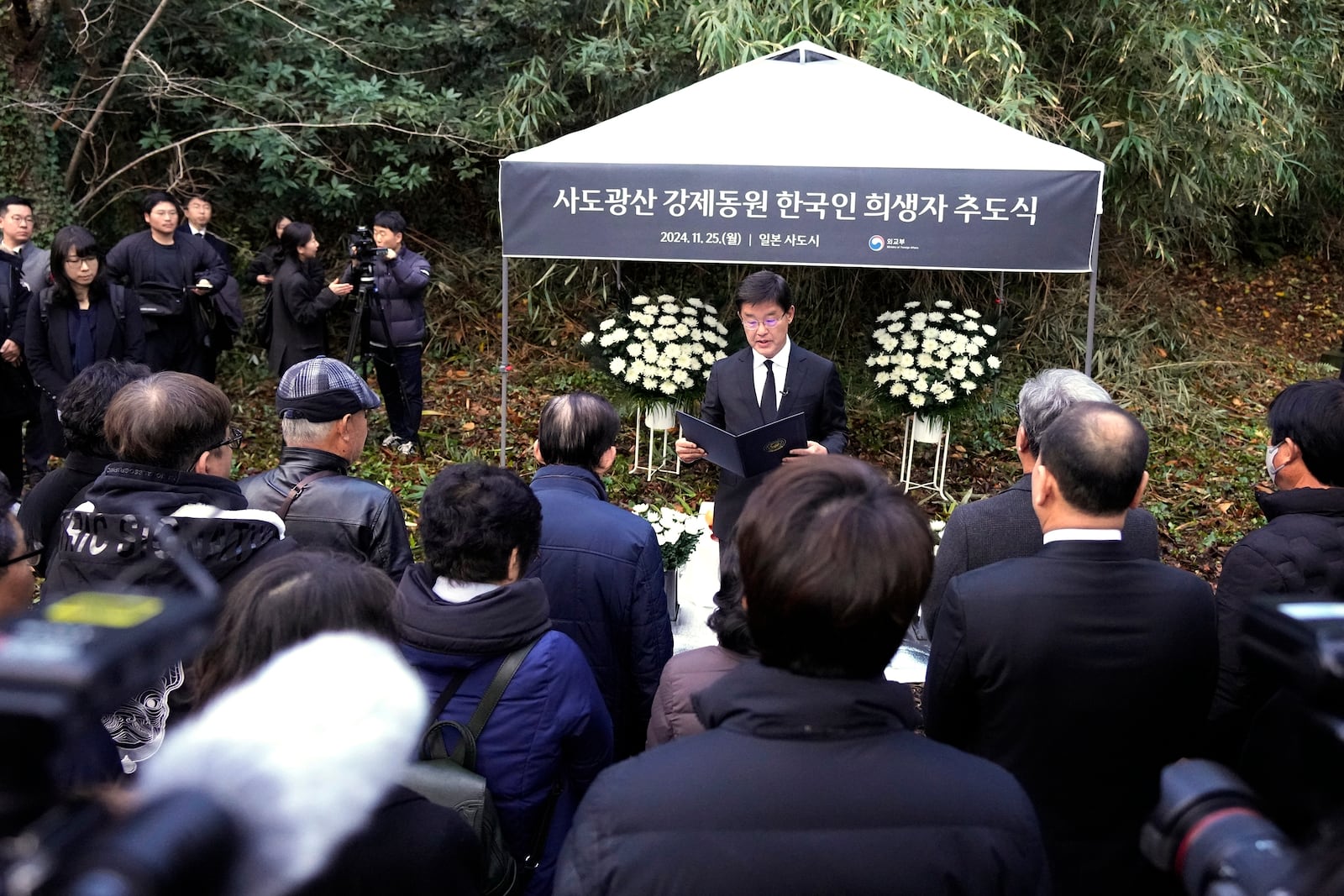 South Korean Ambassador to Japan Park Cheol-hee, center, delivers a speech as relatives of Korean victims and South Korean officials hold a memorial service in Sado, Niigata prefecture, Japan, Monday, Nov. 25, 2024, after boycotting a memorial organized by Japanese officials. (AP Photo/Eugene Hoshiko)