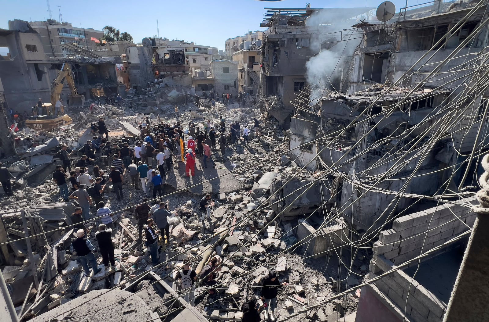 Rescue workers gather at the site of Israeli airstrikes that destroyed buildings facing the city's main government hospital in a densely-populated neighborhood, in southern Beirut, Lebanon, Tuesday, Oct. 22, 2024. (AP Photo/Hussein Malla)