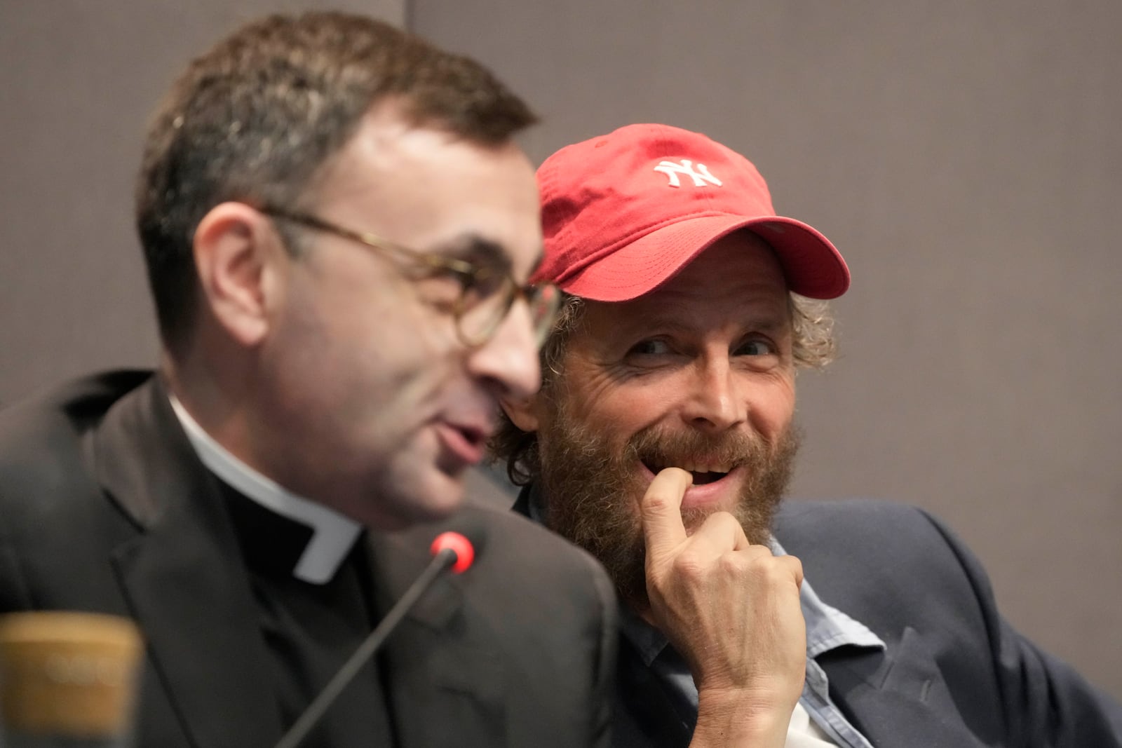 Don Giacomo Cardinali, left, and Italian artist Lorenzo Jovanotti Cherubini attend a press conference presenting the exhibition "En Route" organized by the Vatican Apostolic Library exploring world tours of the late 19th century at the Vatican, Friday, Jan. 31, 2025. (AP Photo/Gregorio Borgia)