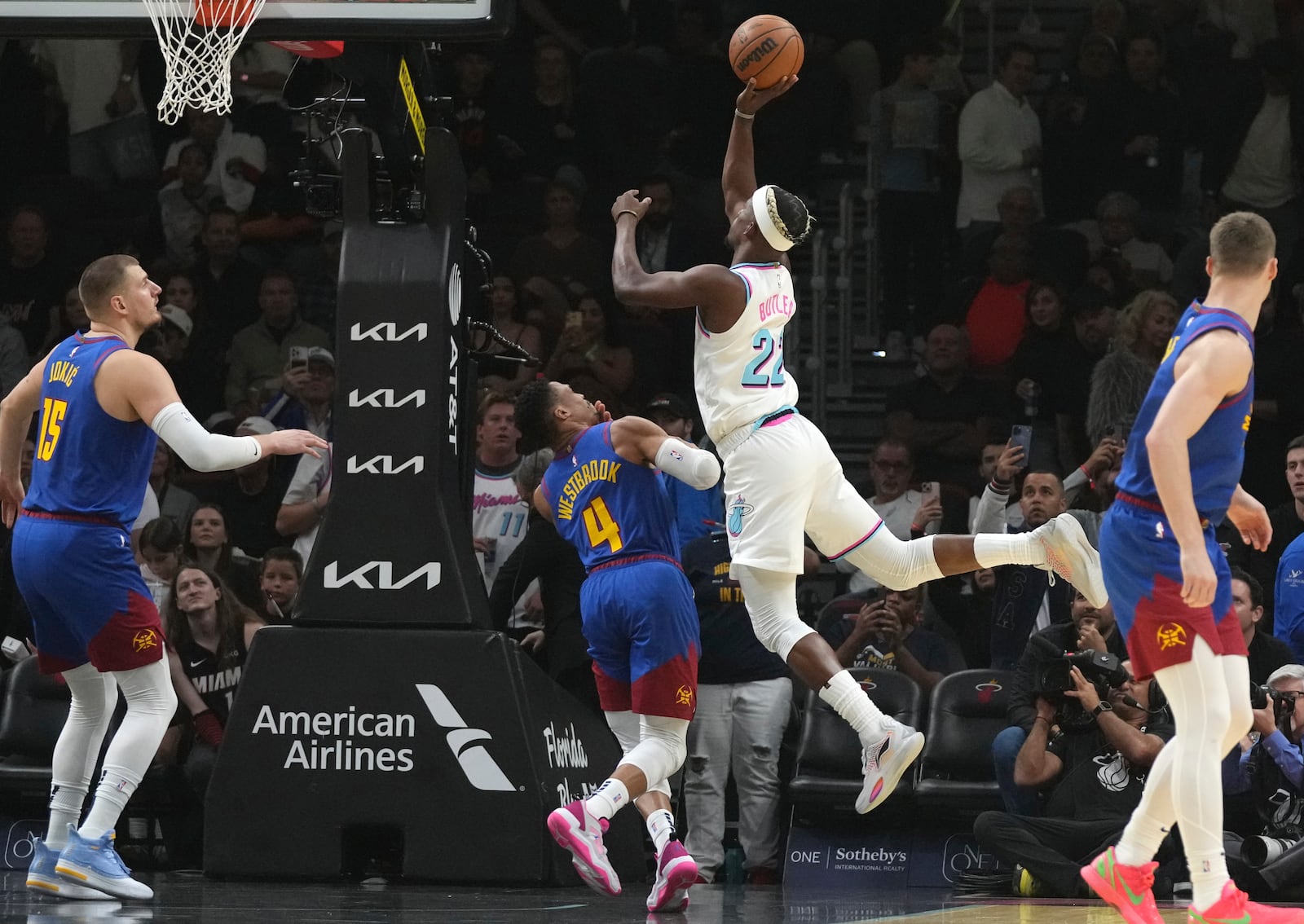 Miami Heat forward Jimmy Butler (22) shoots over Denver Nuggets guard Russell Westbrook (4) during the first half of an NBA basketball game, Friday, Jan. 17, 2025, in Miami. (AP Photo/Lynne Sladky)