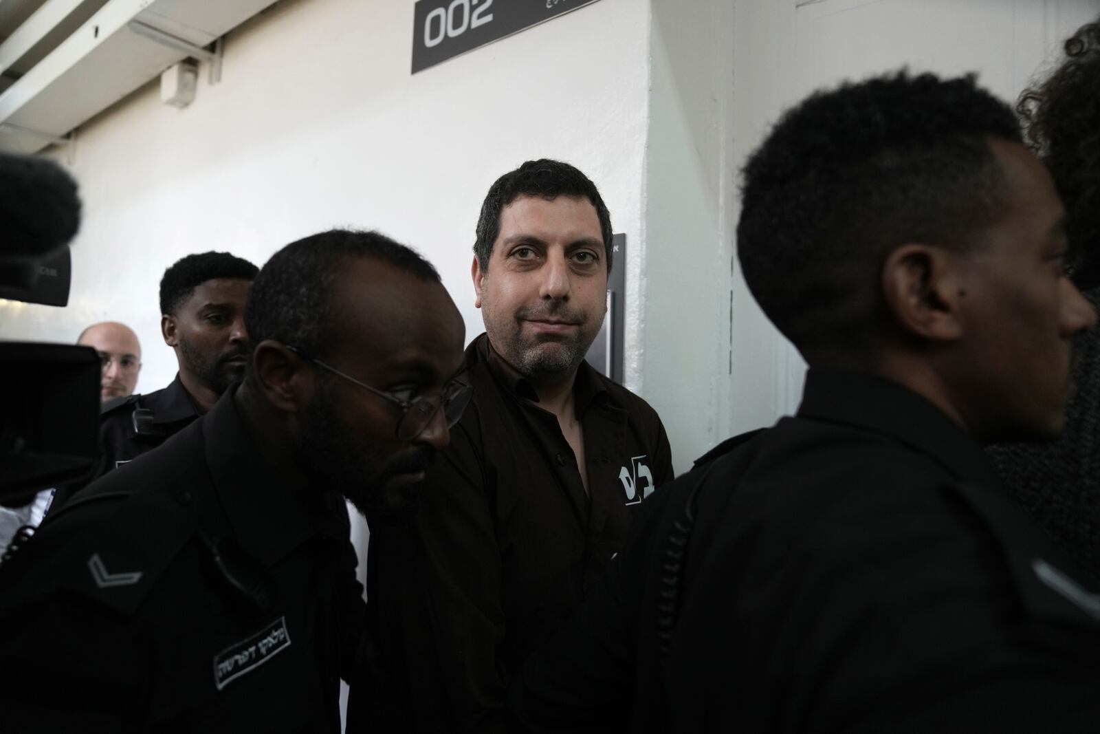 Bookseller Ahmad Muna is led into court after his arrest during an Israeli police have raid of the long-established Palestinian-owned Educational Bookshop in east Jerusalem, Monday, Feb. 10, 2025. (AP Photo/Mahmoud Illean)