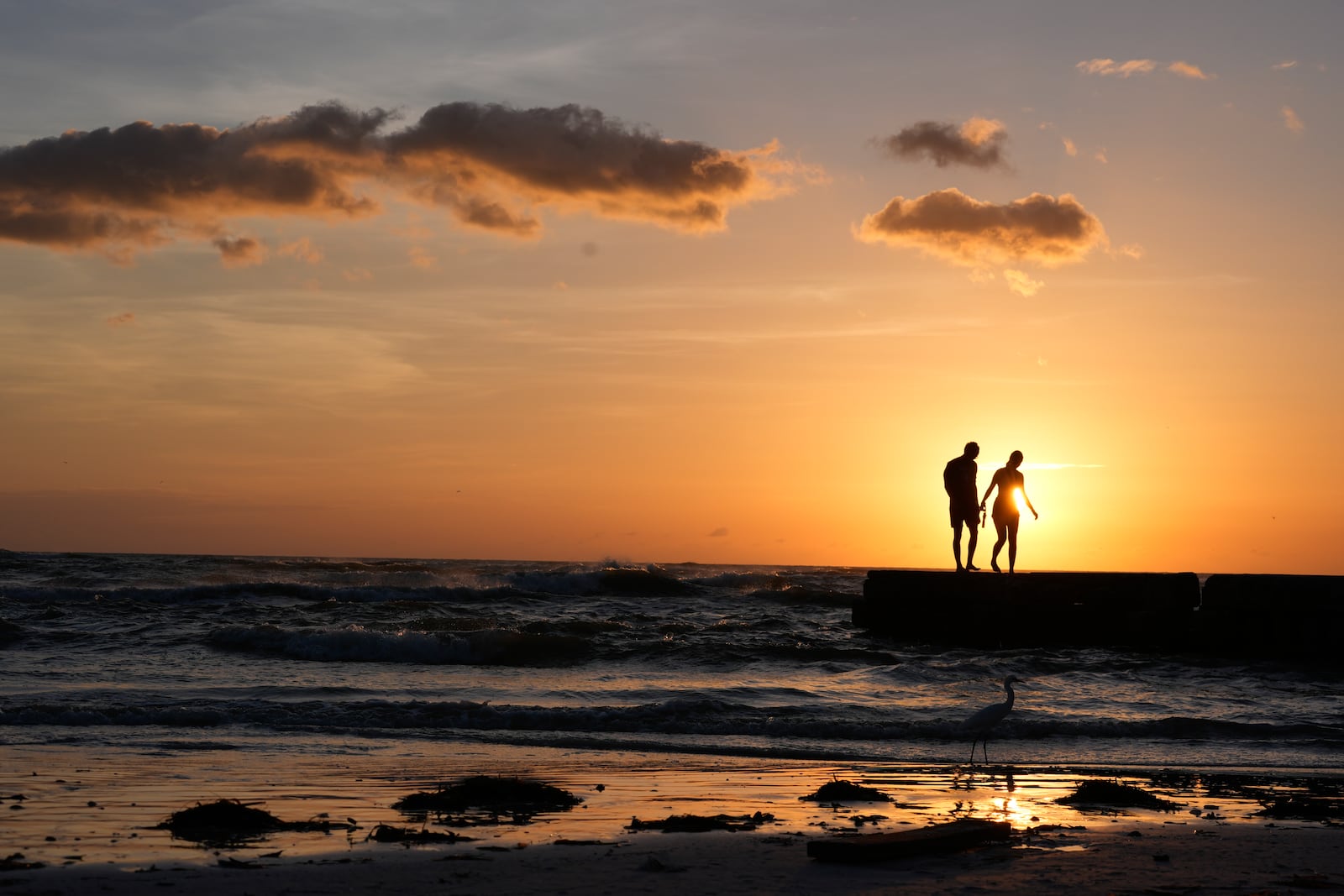 People from Sarasota, Fla., visit a familiar beach on Siesta Key, Fla., which they say was already decimated by Hurricane Helene, and lost feet more of sand coverage in Hurricane Milton, Thursday, Oct. 10, 2024. (AP Photo/Rebecca Blackwell)