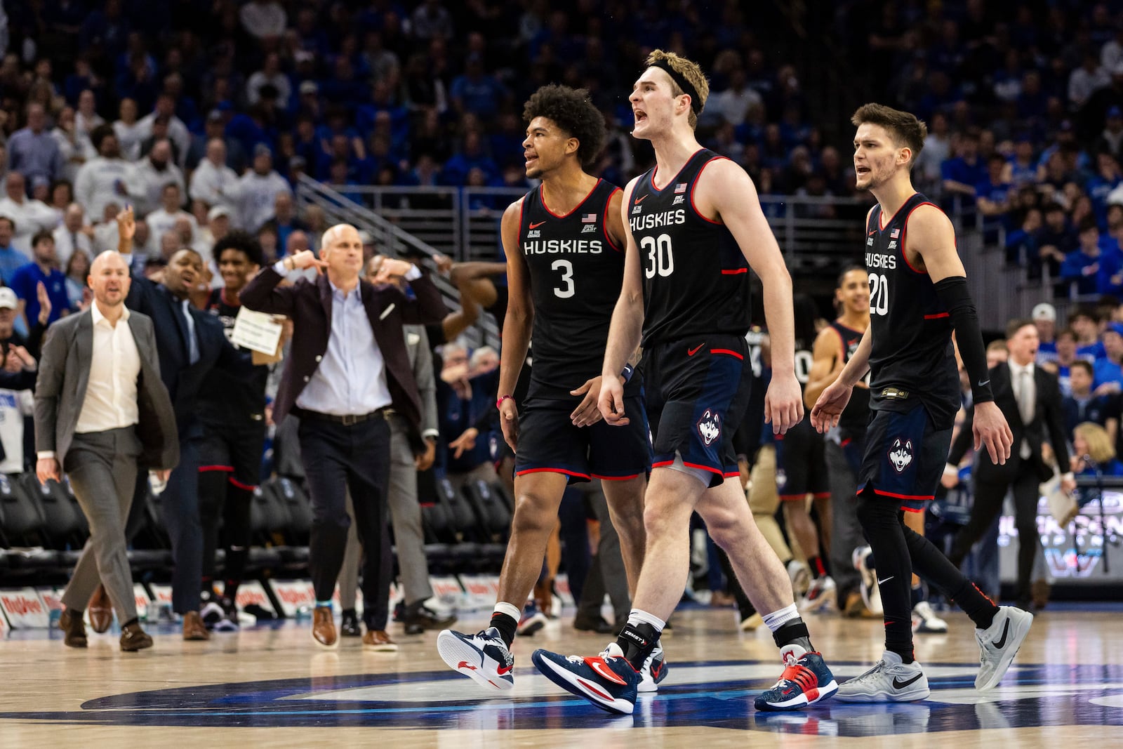 UConn forwards Jaylin Stewart (3) and Liam McNeeley (30) and guard Aidan Mahaney (20) react after a basket against Creighton during the second half of an NCAA college basketball game, Tuesday, Feb. 11, 2025, in Omaha, Neb. (AP Photo/Bonnie Ryan)