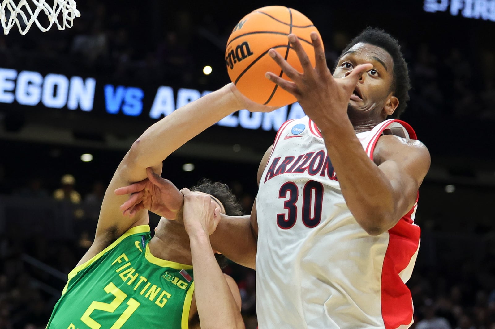 Arizona forward Tobe Awaka, right, and Oregon forward Brandon Angel vie for the ball during the first half in the second round of the NCAA college basketball tournament, Sunday, March 23, 2025, in Seattle. (AP Photo/Ryan Sun)