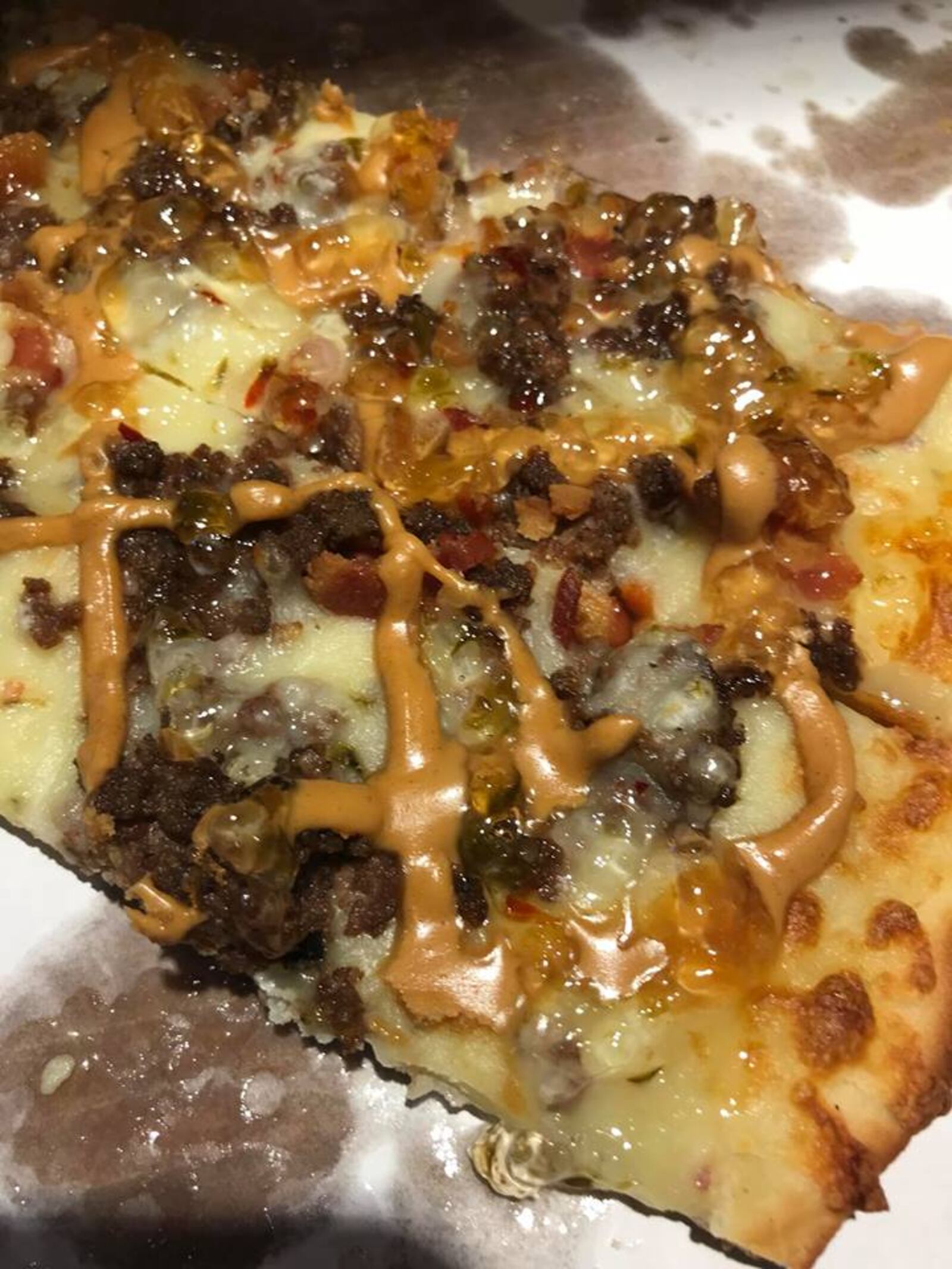 The Tavern Sticky Pizza at The Tavernette Inn.  The pizza is topped with hamburger meat, bacon, pepper jack cheese blend, peanut butter, and jalapeño jelly