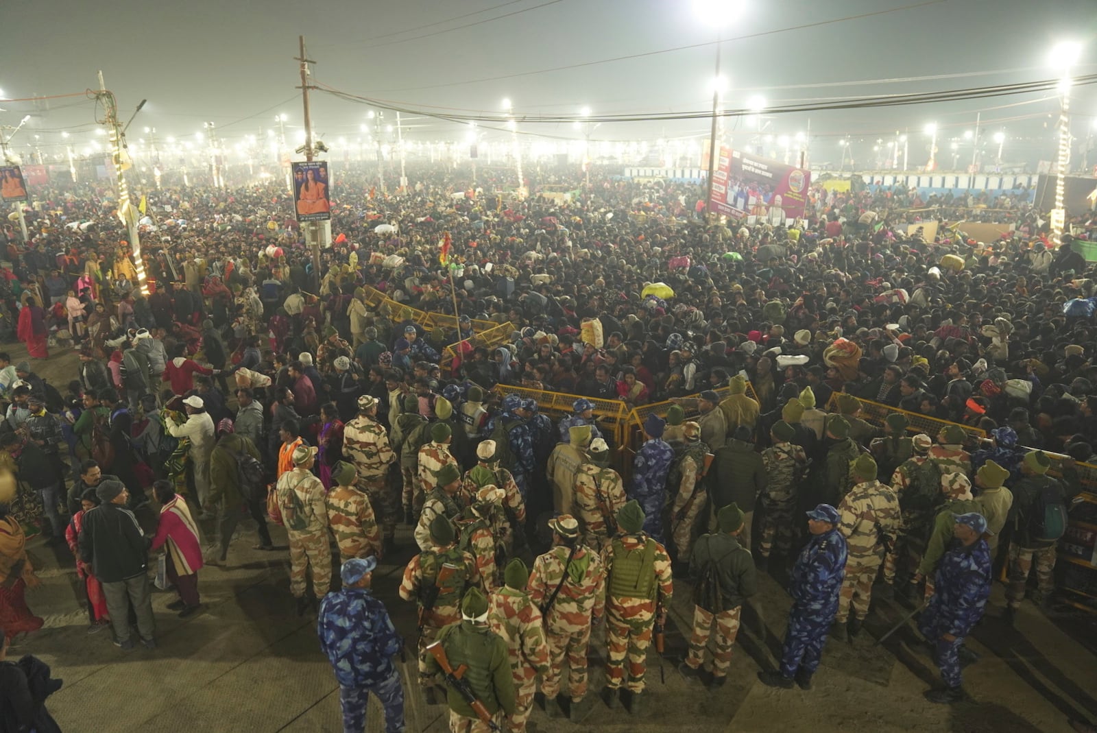 Security officers stand guard at the site of a stampede on the Sangam, the confluence of the Ganges, the Yamuna and the mythical Saraswati rivers, on "Mauni Amavasya" or new moon day during the Maha Kumbh festival, in Prayagraj, Uttar Pradesh, India, Wednesday, Jan. 29, 2025. (AP Photo)