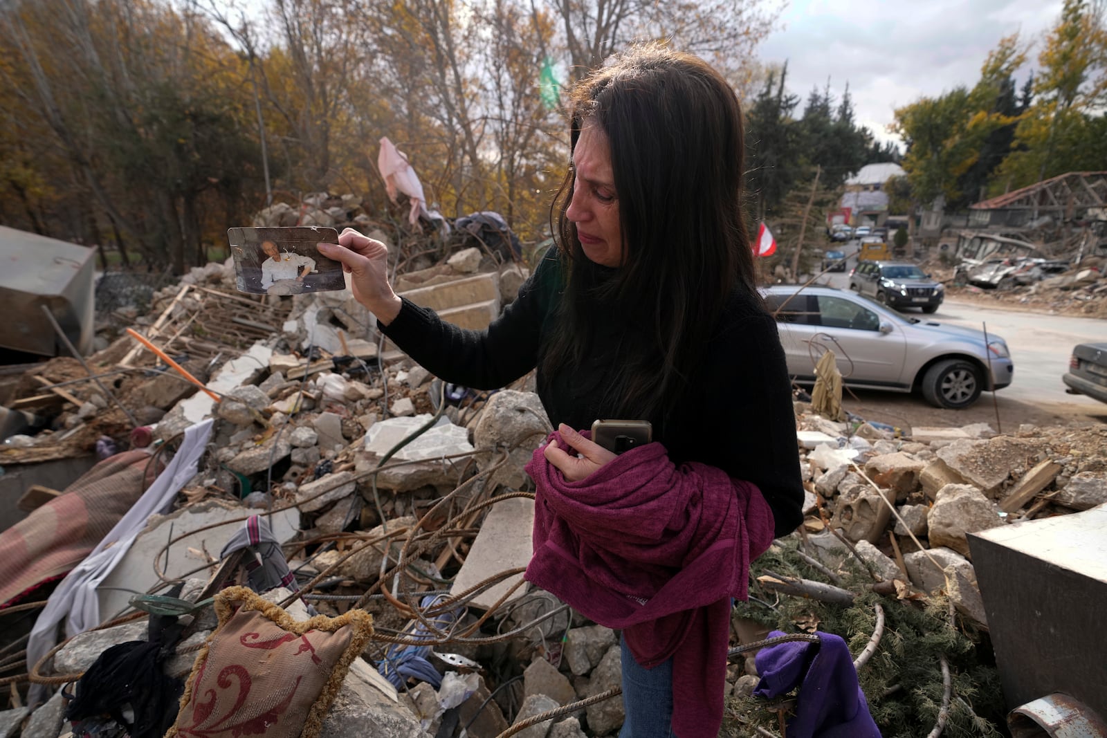 Zeina Rida Jawhari, reacts after recovering a photo of her father from the rubble of her destroyed house in Baalbek, eastern Lebanon, Thursday, Nov. 28, 2024. (AP Photo/Hassan Ammar)