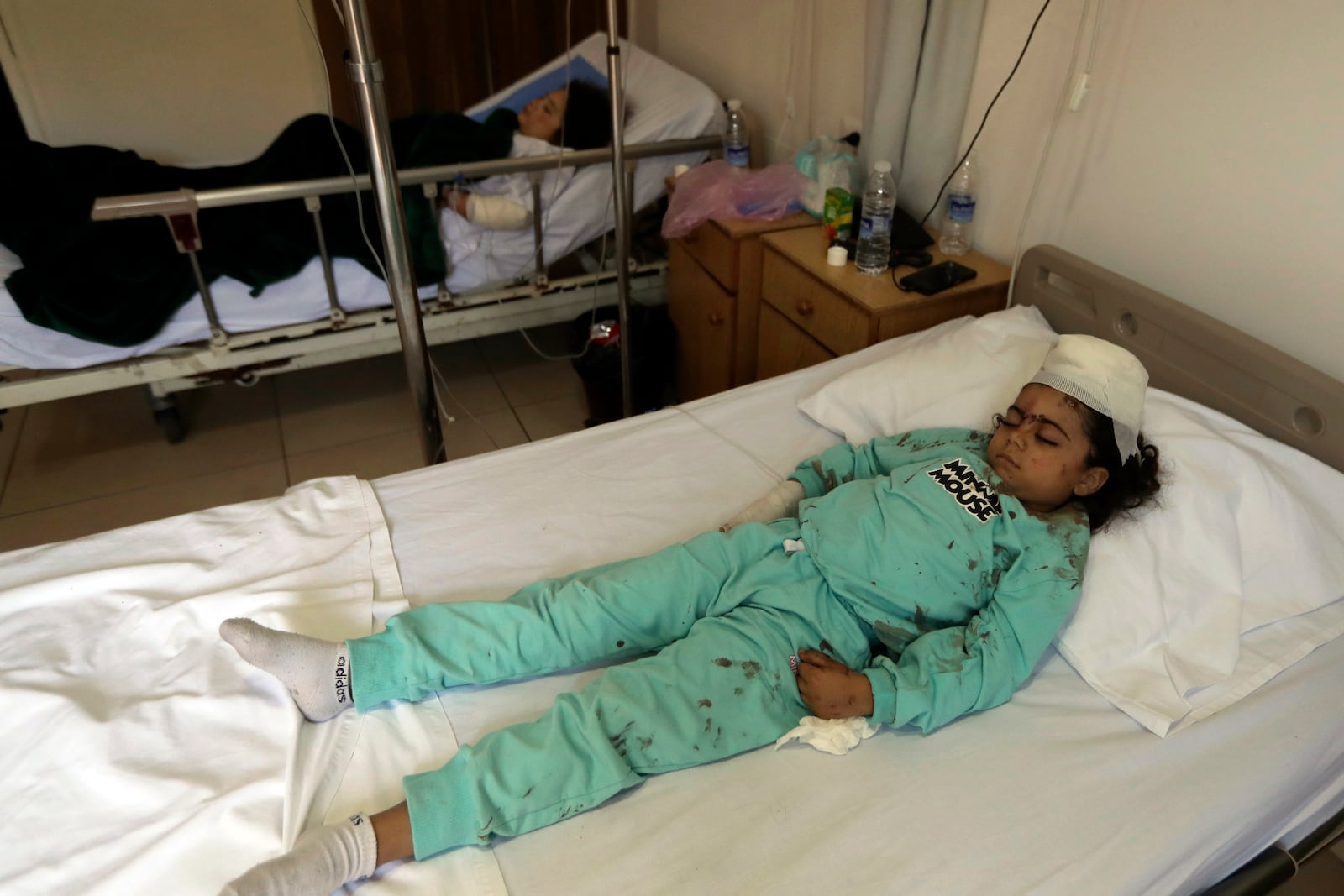 Yasmina Khalifa, foreground and her sister Julia, who were injured Tuesday night in an Israeli airstrike that hit their building, lie in hospital beds in Sarafand, southern Lebanon, Wednesday, Oct. 30, 2024. (AP Photo/Mohammad Zaatari)