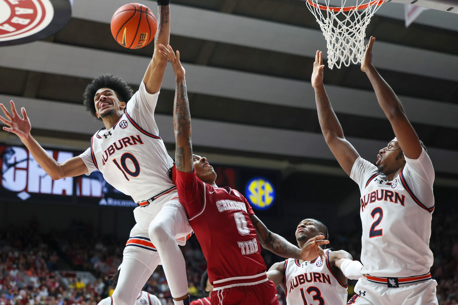 Auburn's Chad Baker-Mazara (10) goes for a block over Alabama guard Labaron Philon (0) during the second half of an NCAA college basketball game, Saturday, Feb. 15, 2025, in Tuscaloosa, Ala. Also in the photo are Auburn's Miles Kelly (13) and Denver Jones (2). (AP Photo/Vasha Hunt)