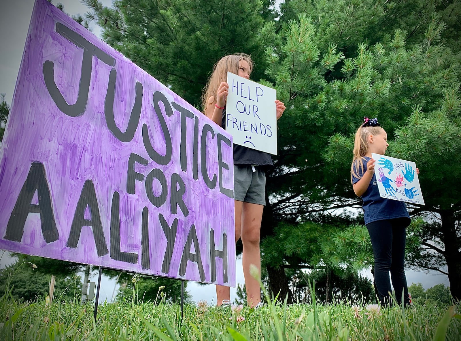 A 2021 protest over the handling of complaints in connection to Aaliyah Artis, a 12-year old girl who died in Xenia, took place on front of Greene County Children Services.  Wearing a bow, Joezie Jobes, and Lily Redmond, hold signs at the protest. MARSHALL GORBY\STAFF