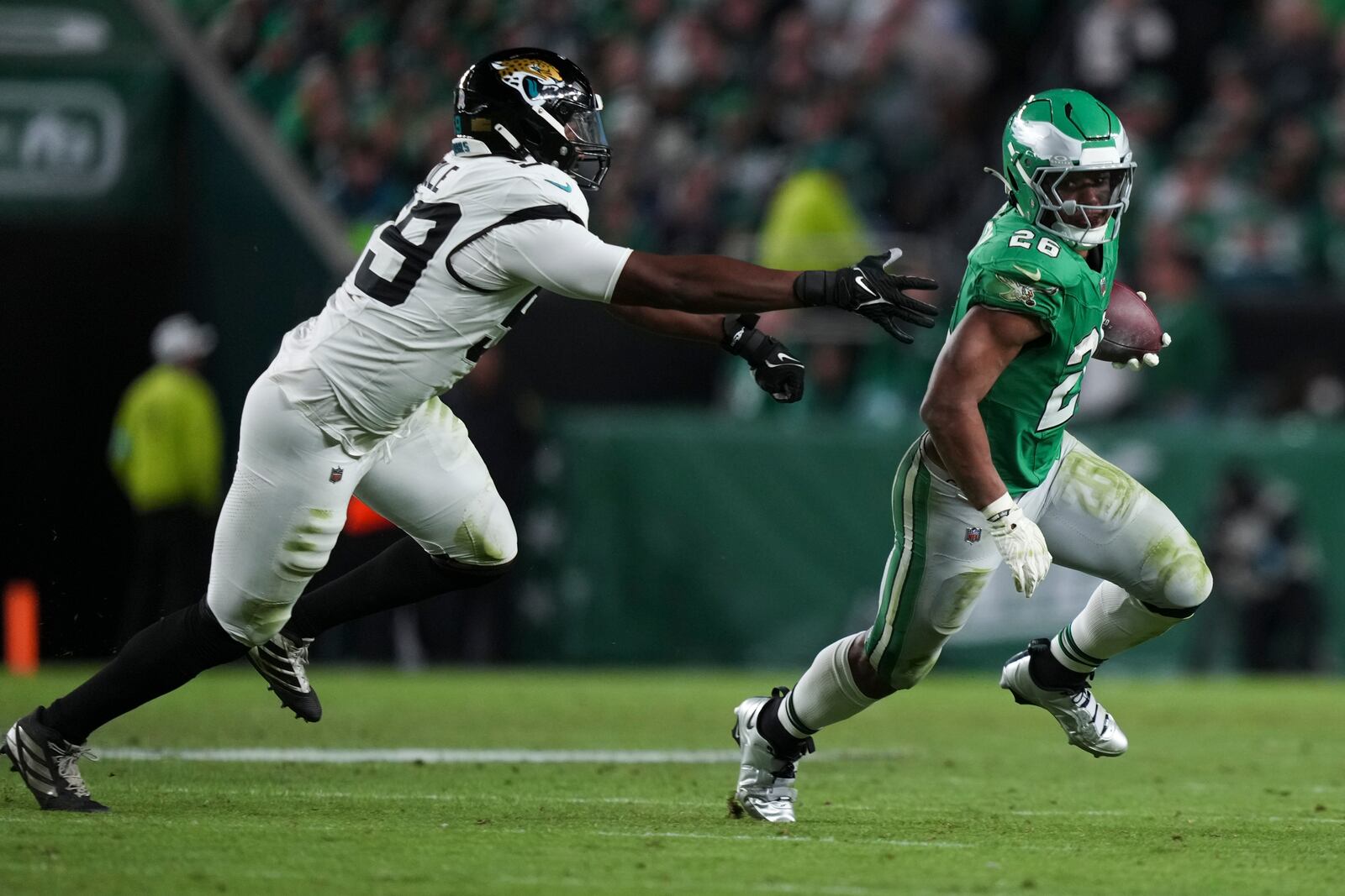 Philadelphia Eagles running back Saquon Barkley (26) gets past Jacksonville Jaguars defensive end Myles Cole (59) during the second half of an NFL football game Sunday, Nov. 3, 2024, in Philadelphia. (AP Photo/Matt Slocum)