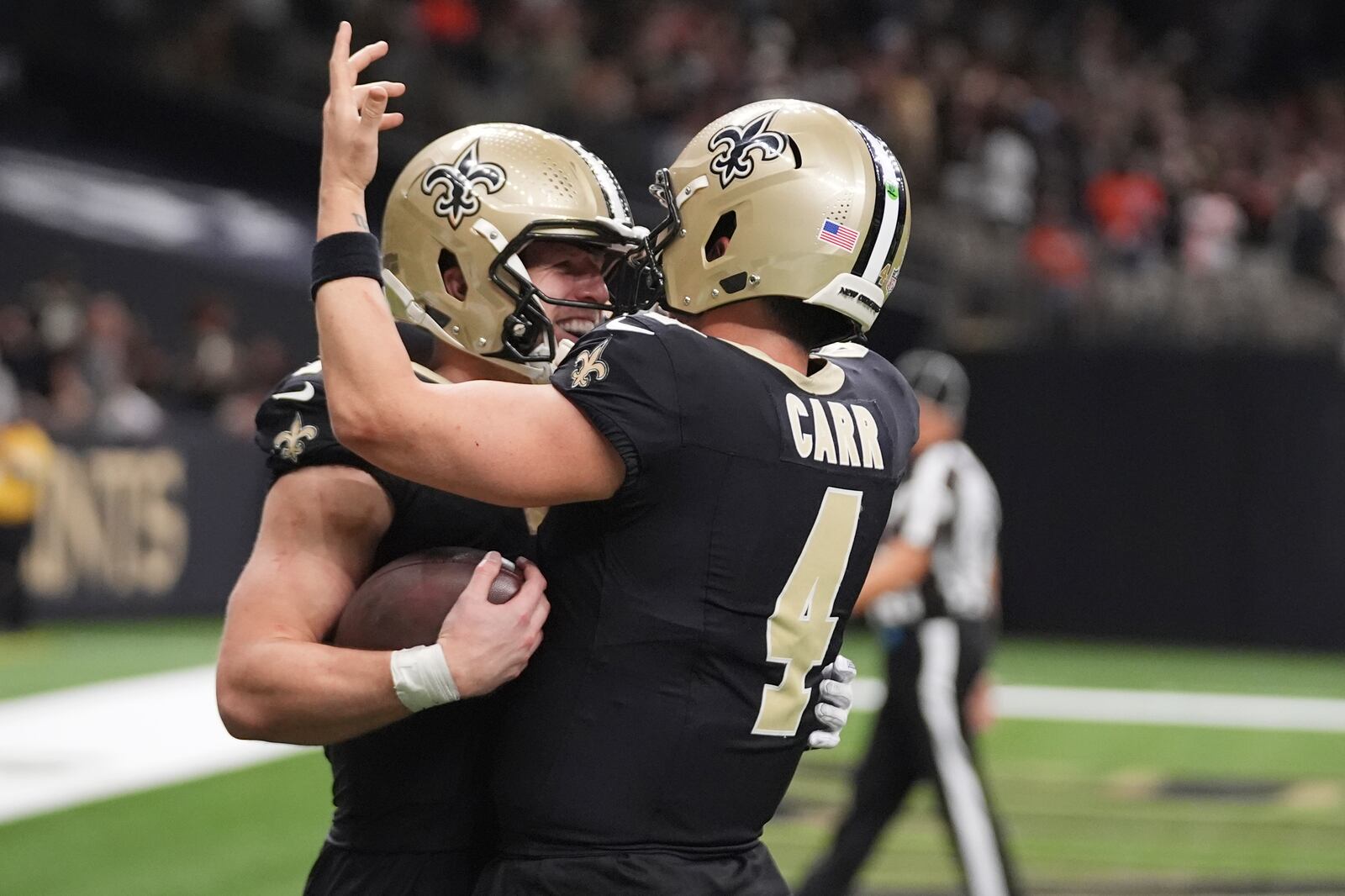 New Orleans Saints tight end Taysom Hill, left, celebrates a touchdown with quarterback Derek Carr (4) in the second half of an NFL football game in New Orleans, Sunday, Nov. 17, 2024. (AP Photo/Gerald Herbert)