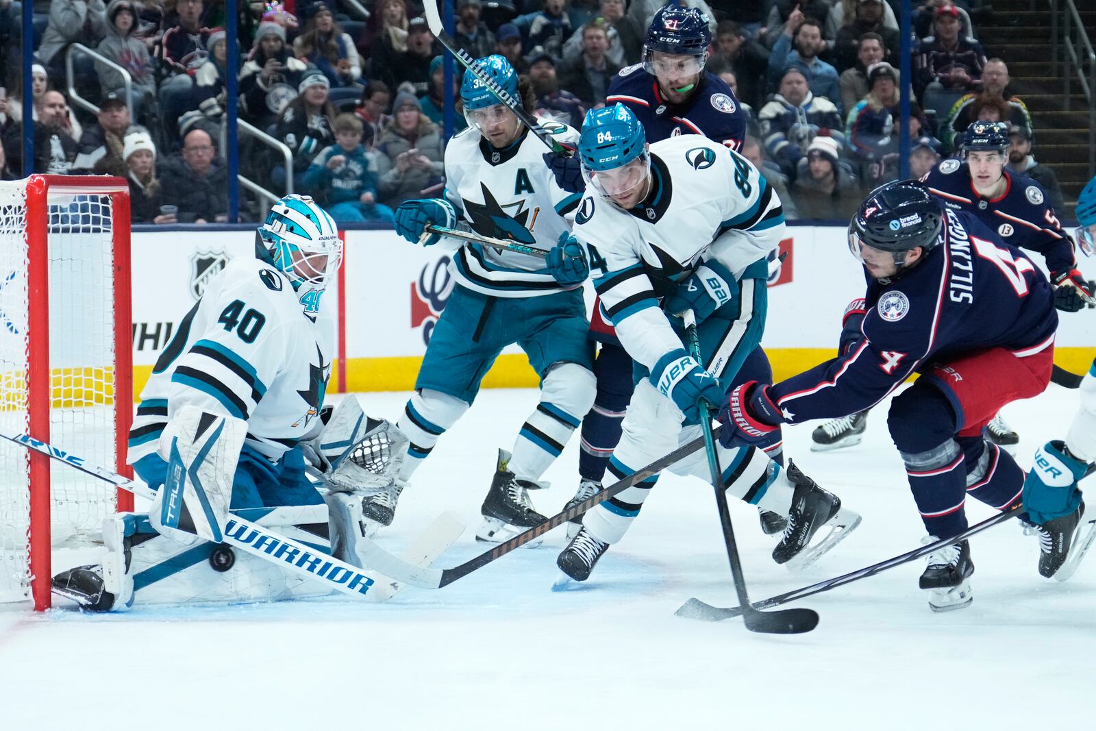 San Jose Sharks goaltender Alexandar Georgiev (40) blocks a shot by Columbus Blue Jackets center Cole Sillinger (4) in the second period of an NHL hockey game Thursday, Jan. 16, 2025, in Columbus, Ohio. (AP Photo/Sue Ogrocki)